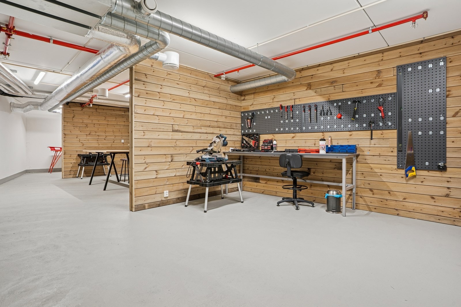 I kjelleren finner du et stort hobbyrom som er praktisk innredet med arbeidsbenker, høvelbenk, hyller og sykkelstativ. Galleribilde