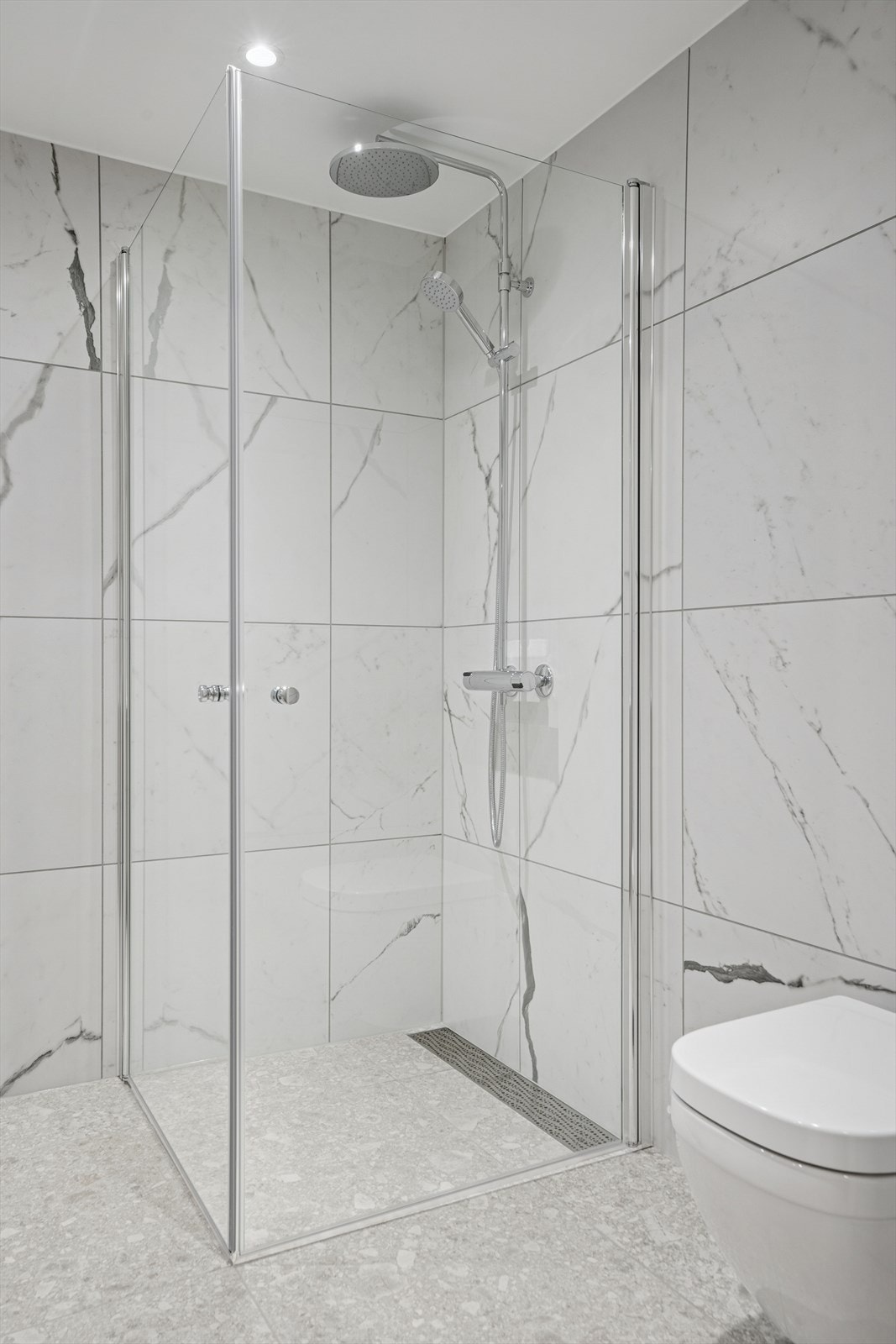 Hvert bad er utstyrt med vegghengt toalett, moderne servantinnredning med skuffer og speil over. Galleribilde