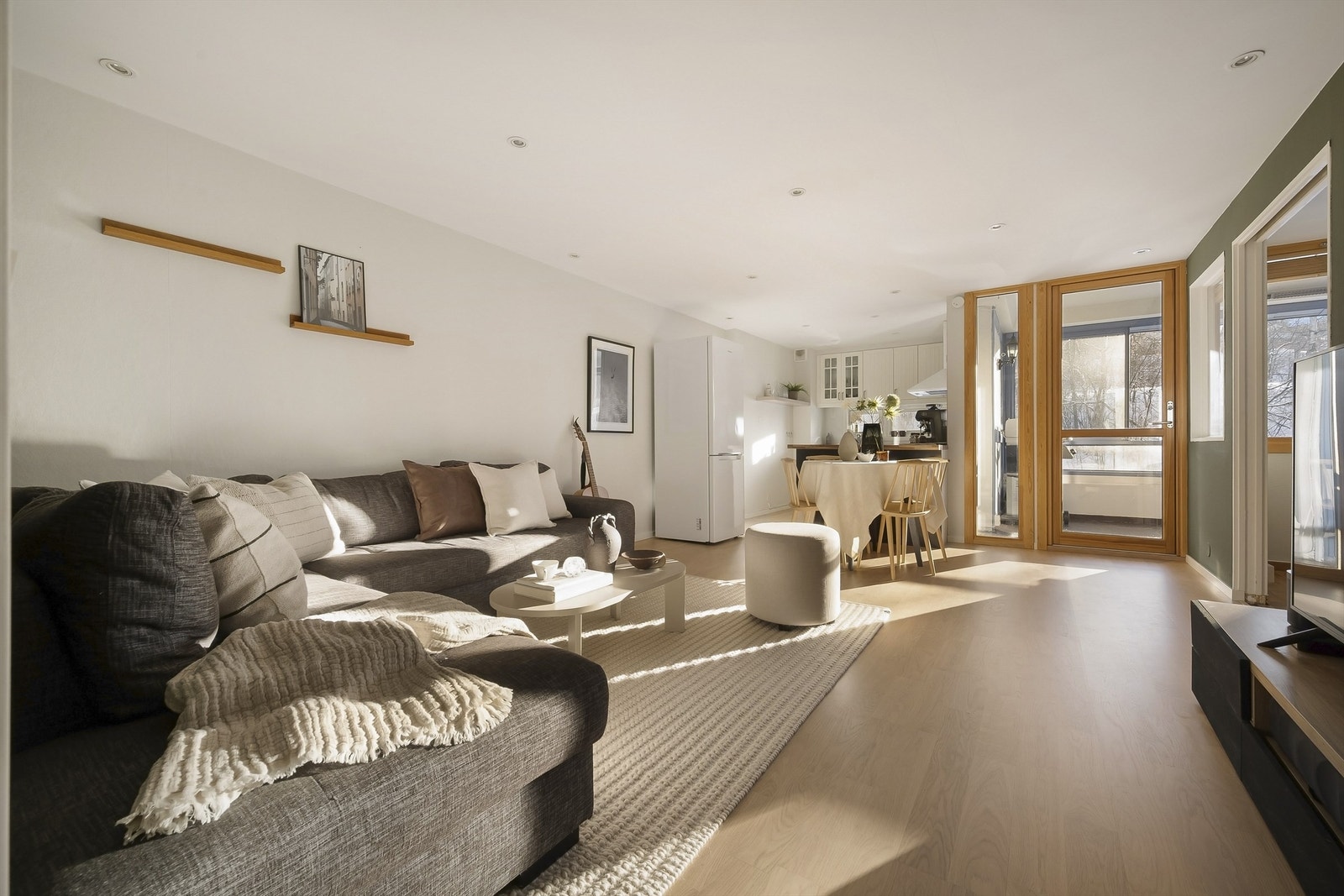 Stue med åpen kjøkkenløsning - legg merke til alt det herlige lysinnslippet du får i leiligheten. Galleribilde