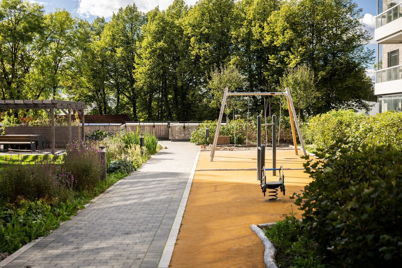 Det er flotte fellesareal med sittegrupper og lekeapparat for de minste rett utenfor boligen. Galleribilde