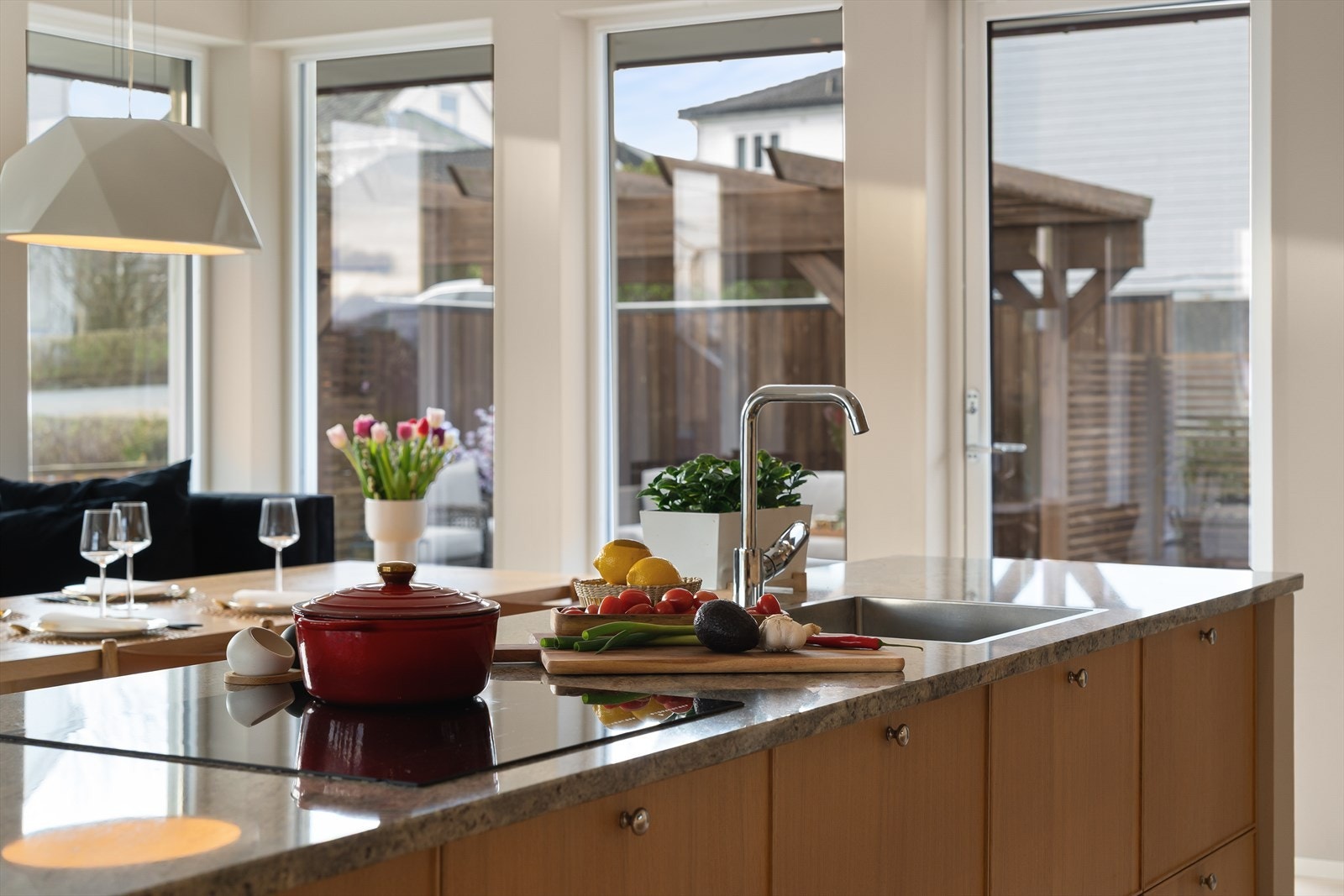 Nedfelt vask og platetopp vendt mot stuen og spisestuen - ideelt for sosial matlaging Galleribilde