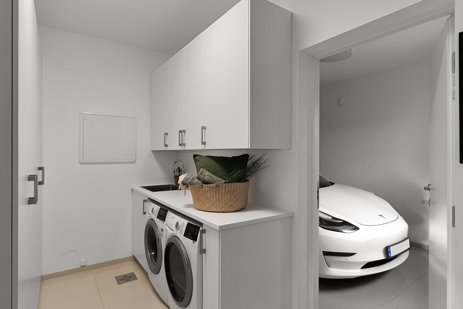 Vaskerom med store fliser og gulvvarme. Videre fra vaskerommet er det gjennomgang til garasjen Galleribilde