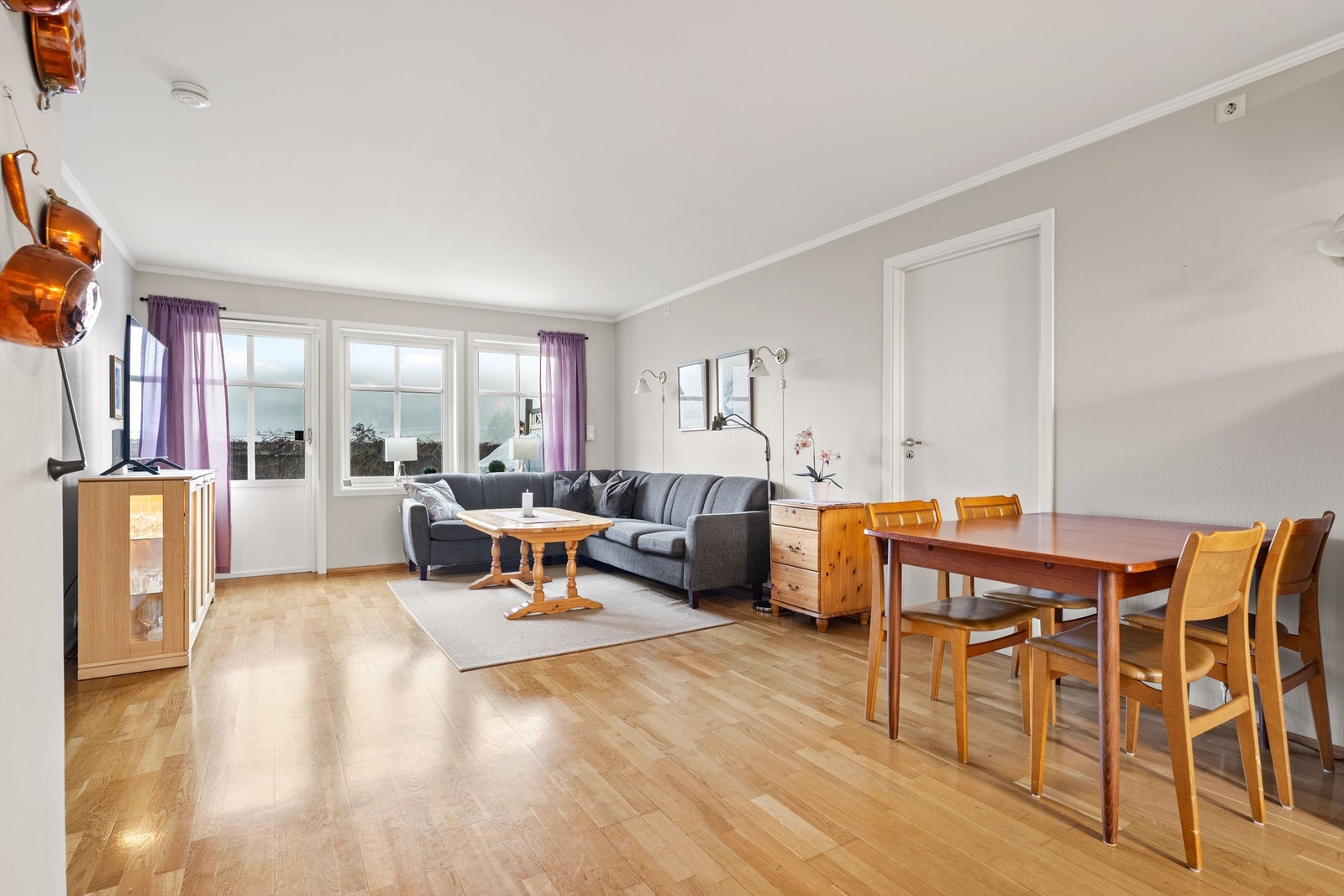 Åpen kjøkken- og stueløsning med sofaområde samt spiseplass Galleribilde