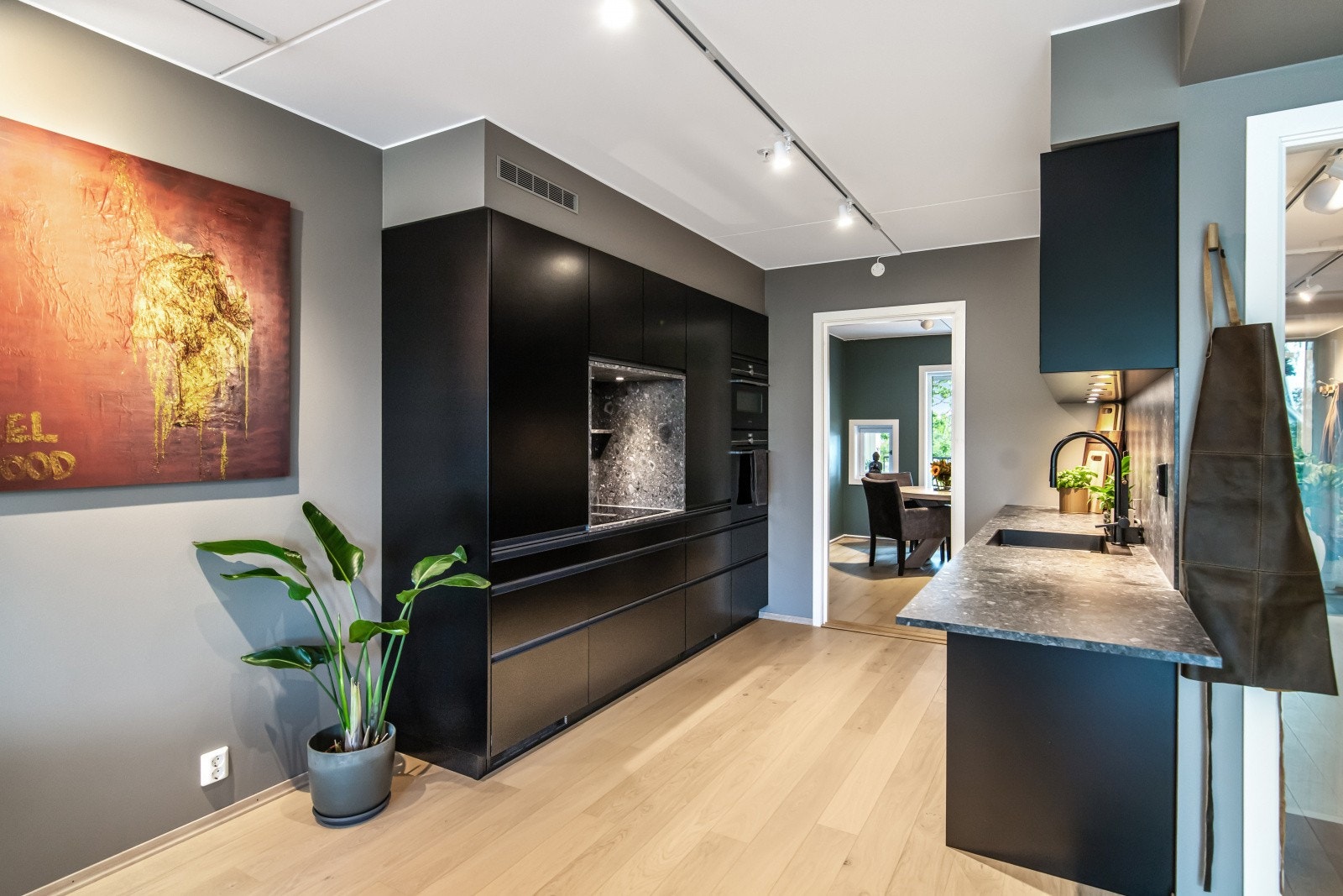 Innredningen har sorte, glatte fronter med gripekant og benkeplate i tynn, steinmønstret lamina. Galleribilde