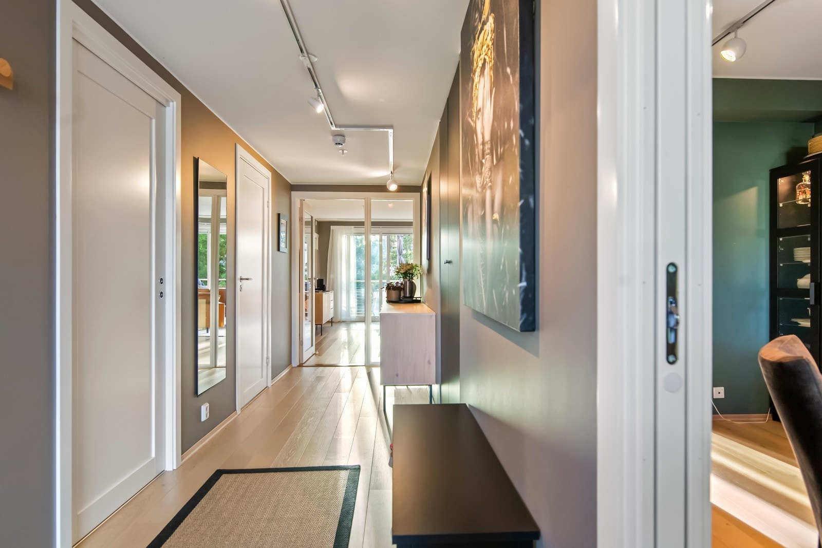 Entreen er innbydende med enstavs parkettgulv, listefri himling med spotskinne og glatte vegger malt i en varmgrå nyanse. Galleribilde