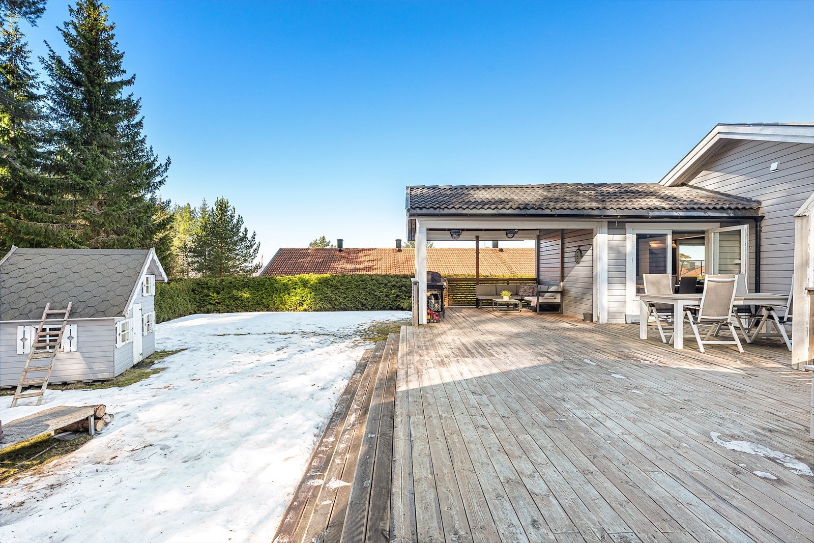 Stor terrasse på 60 m² med god plass til grill og ønsket utemøblement. Deler av terrassen er overbygget, og her er det videre adkomst direkte ut til hagen Galleribilde
