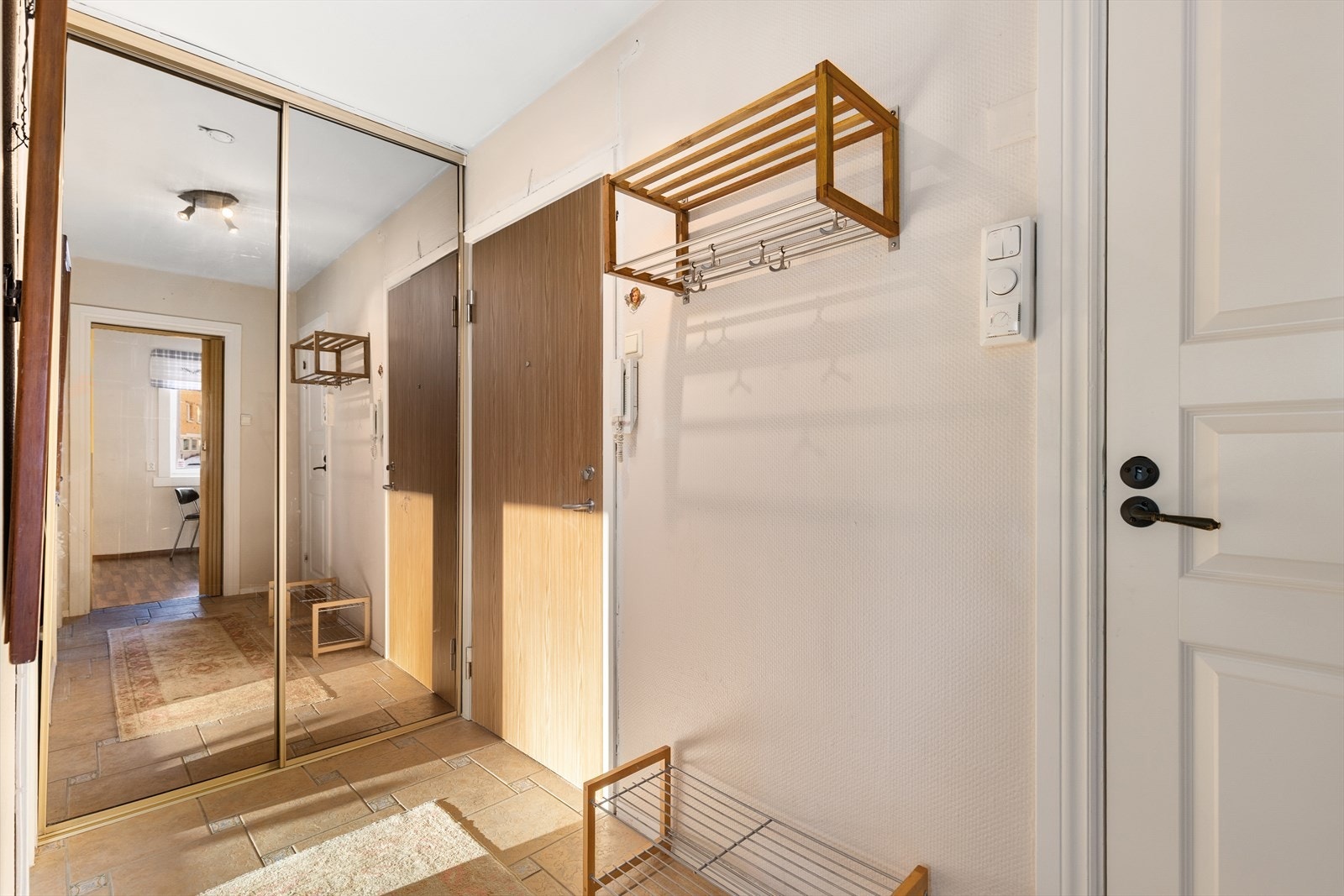 Smart og mye oppbevaringsplass i skyvedørsgarderobe med speilfronter. Brann- og lydklassifisert entrédør B60. Galleribilde