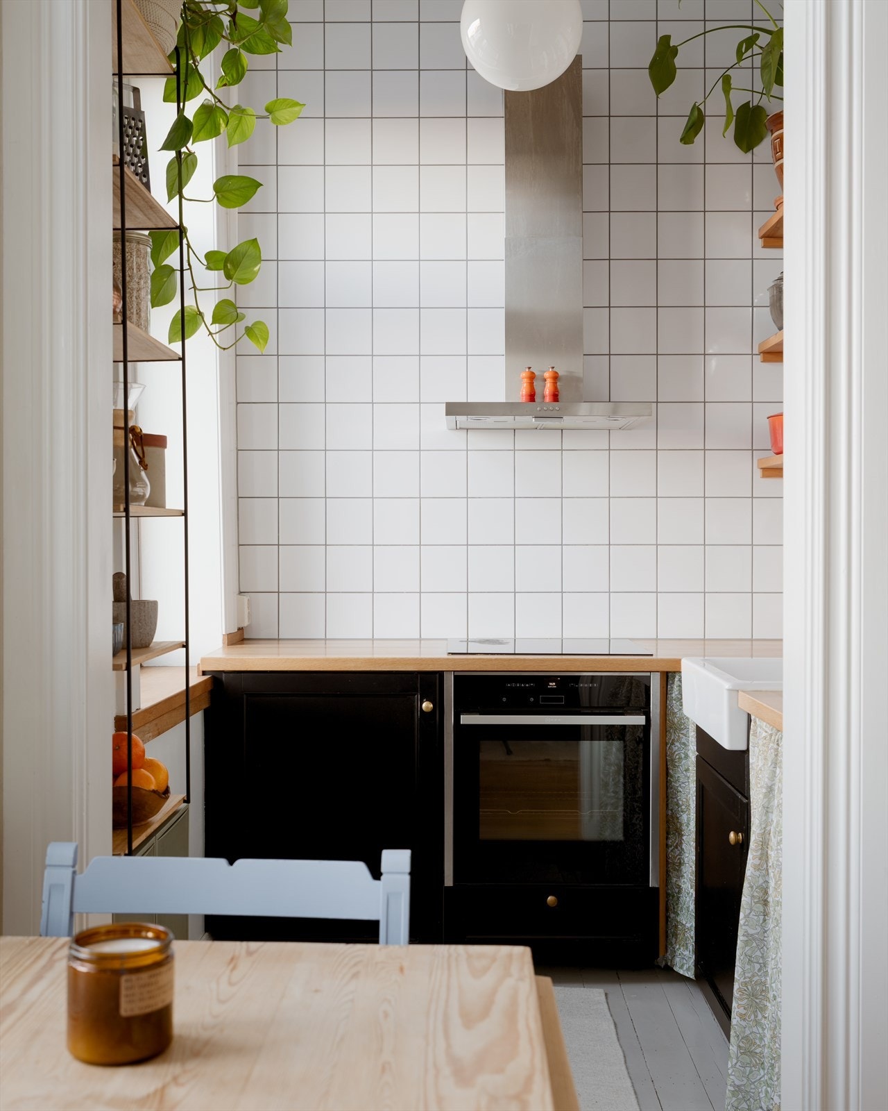 Kjøkkeninnredningen har profilerte, sorte fronter, veggmonterte hyller, dobbelt vitrineskap og benkeplate i heltre eik. Galleribilde