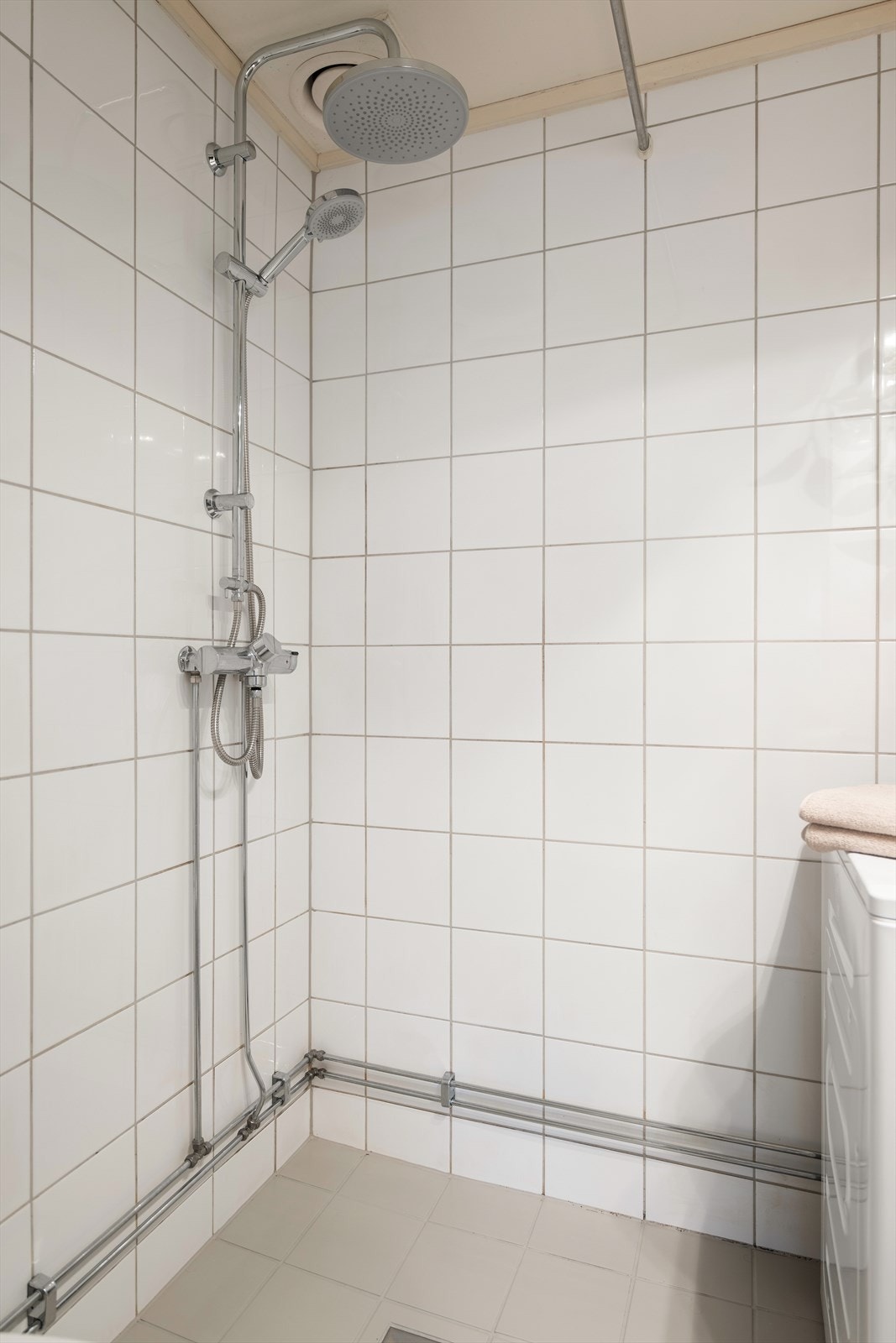 Videre er det en åpen dusjløsning med forheng og praktisk opplegg for vaskemaskin. Galleribilde
