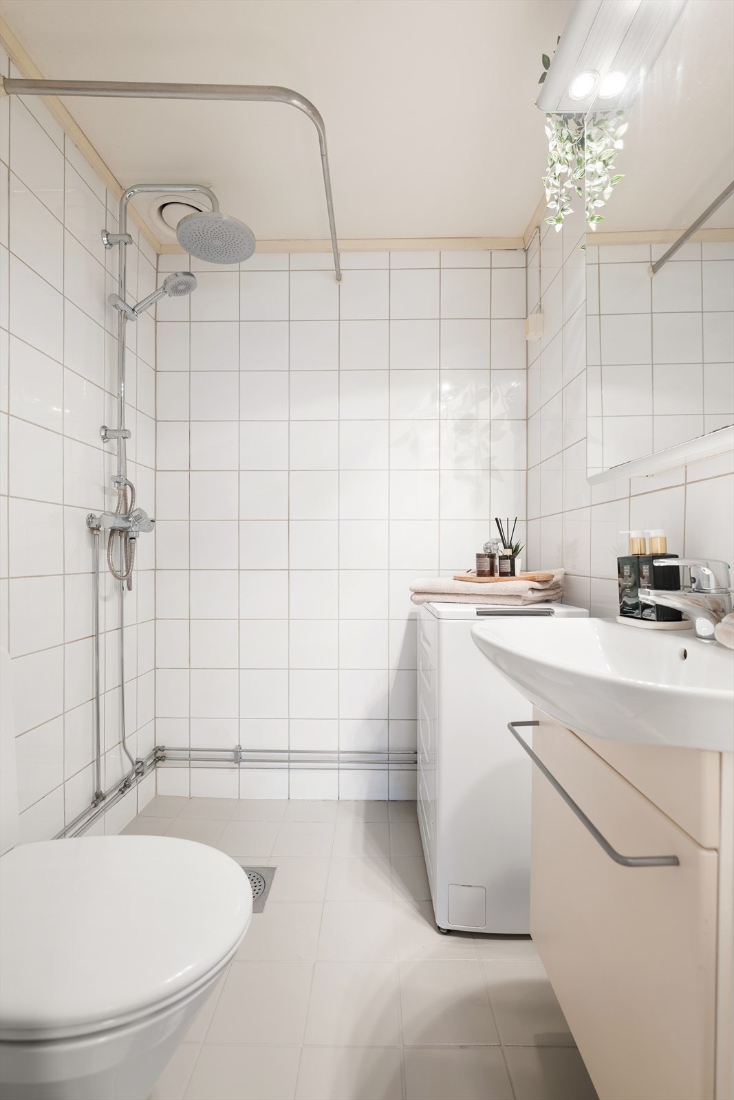 Innredningen består av en servant med underskap, et speilskap med overlys og et gulvmontert klosett. Galleribilde