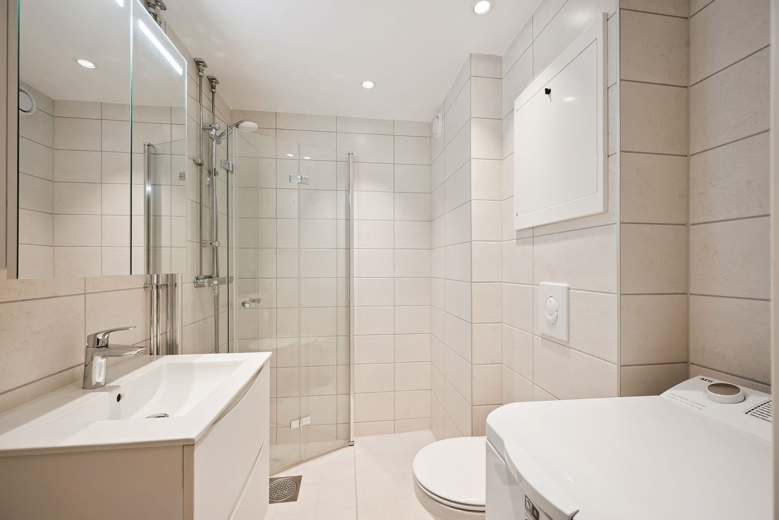 Moderne baderomsinnredning med funksjonell lagringsplass og spotlights. Galleribilde