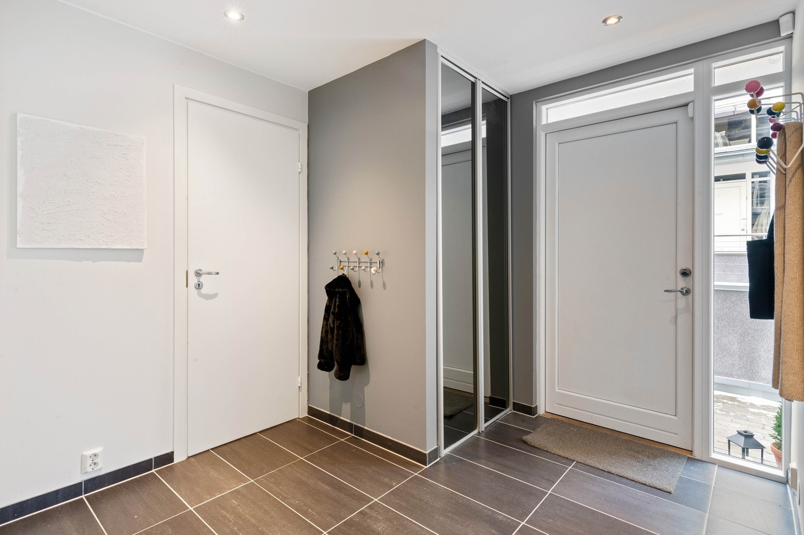 Innbydende og flislagt entré med downlights, varmekabler og integrert garderobeløsning Galleribilde