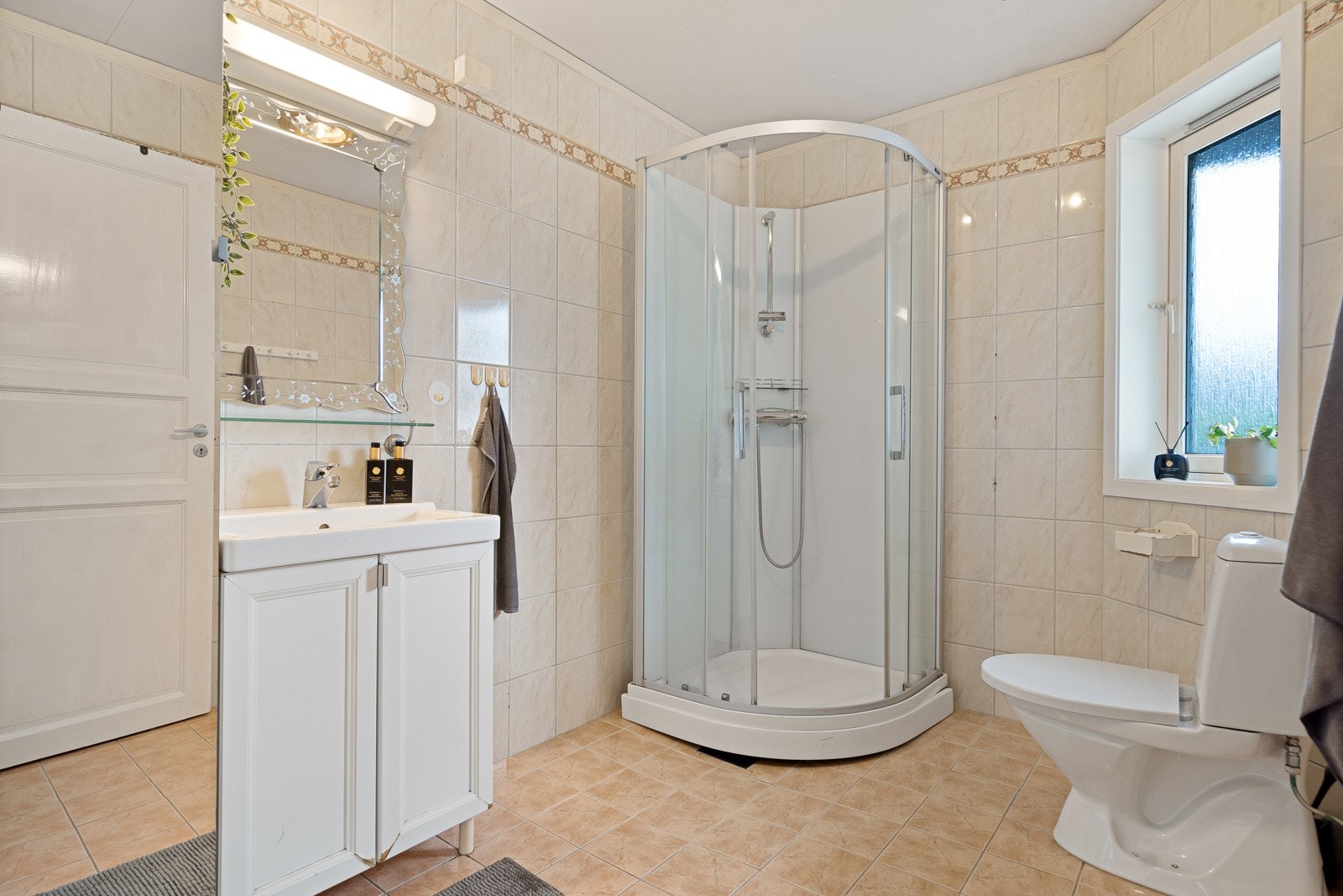 Boligen har to bad, begge med fliser, servant, toalett og dusjløsning. Galleribilde