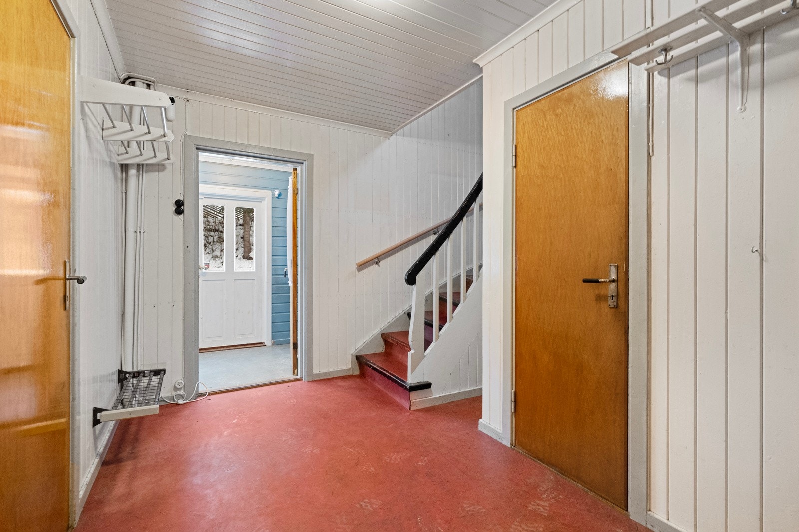 Romslig trapperom med dør til kjeller og trapp til 2.etg. Galleribilde