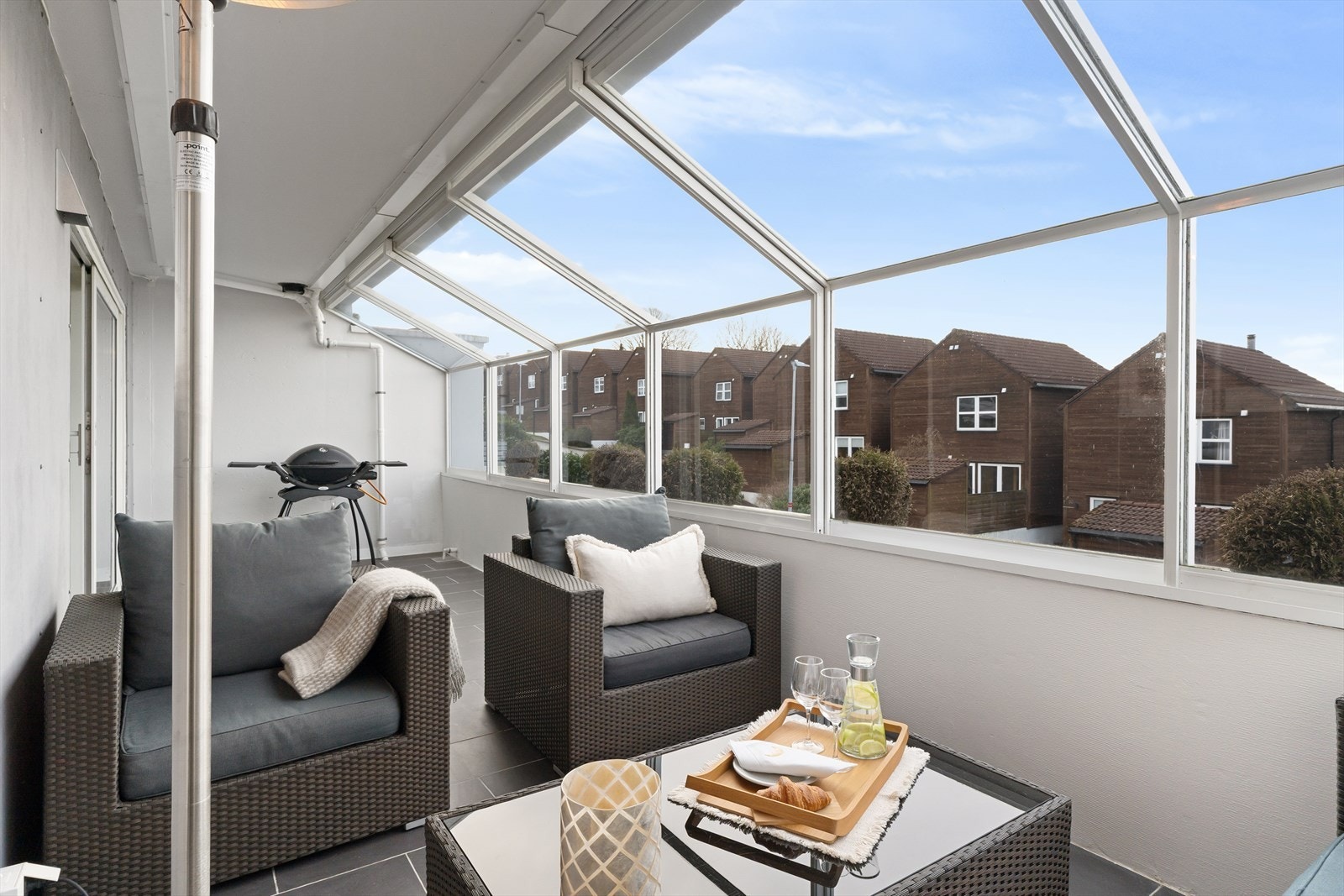 Utgang til en romslig innglasset vestvendt balkong med fliser på gulv og meget gode solforhold Galleribilde