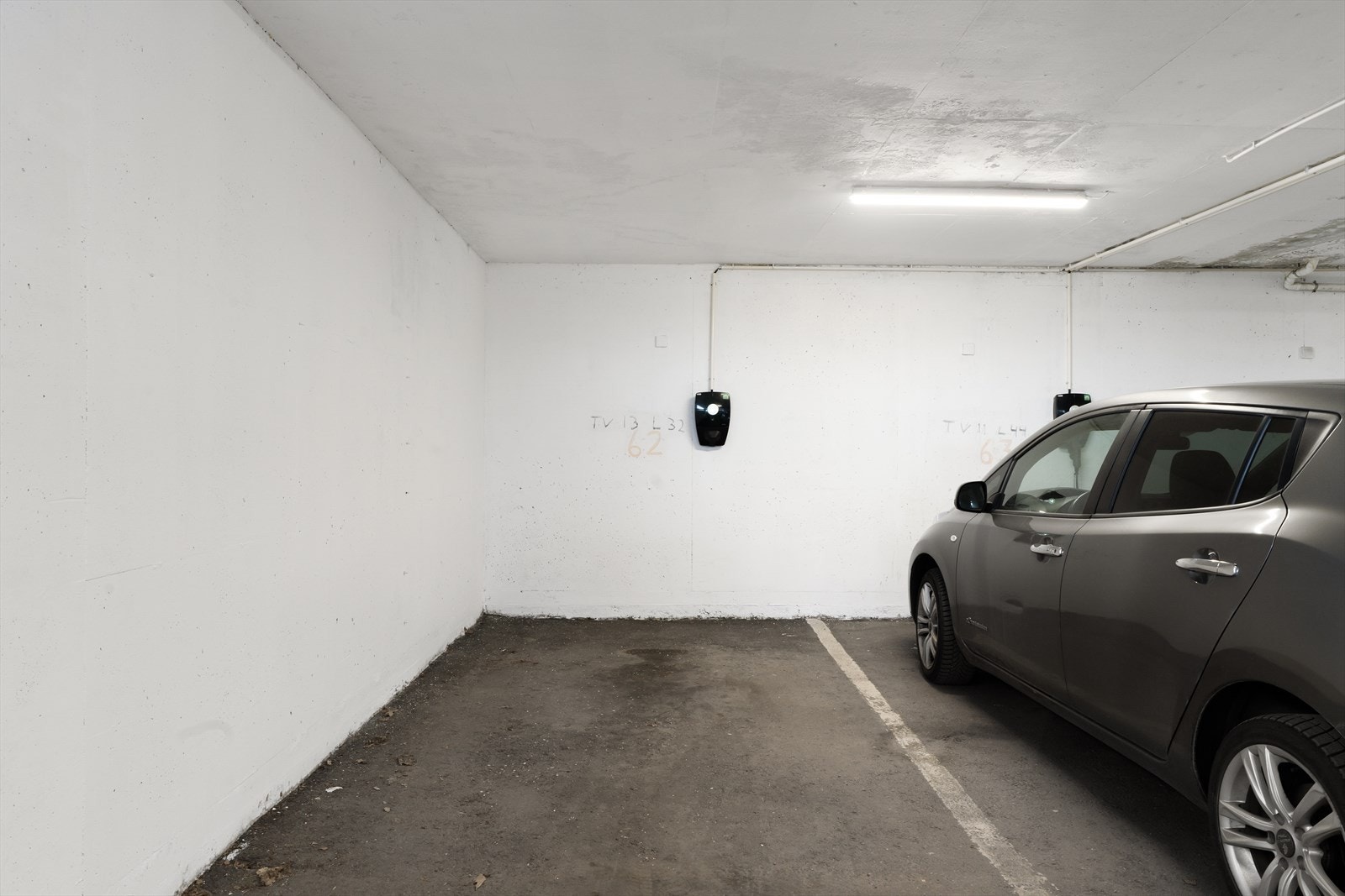 En fast parkeringsplass med elbil-lader i lukket garasjeanlegg Galleribilde