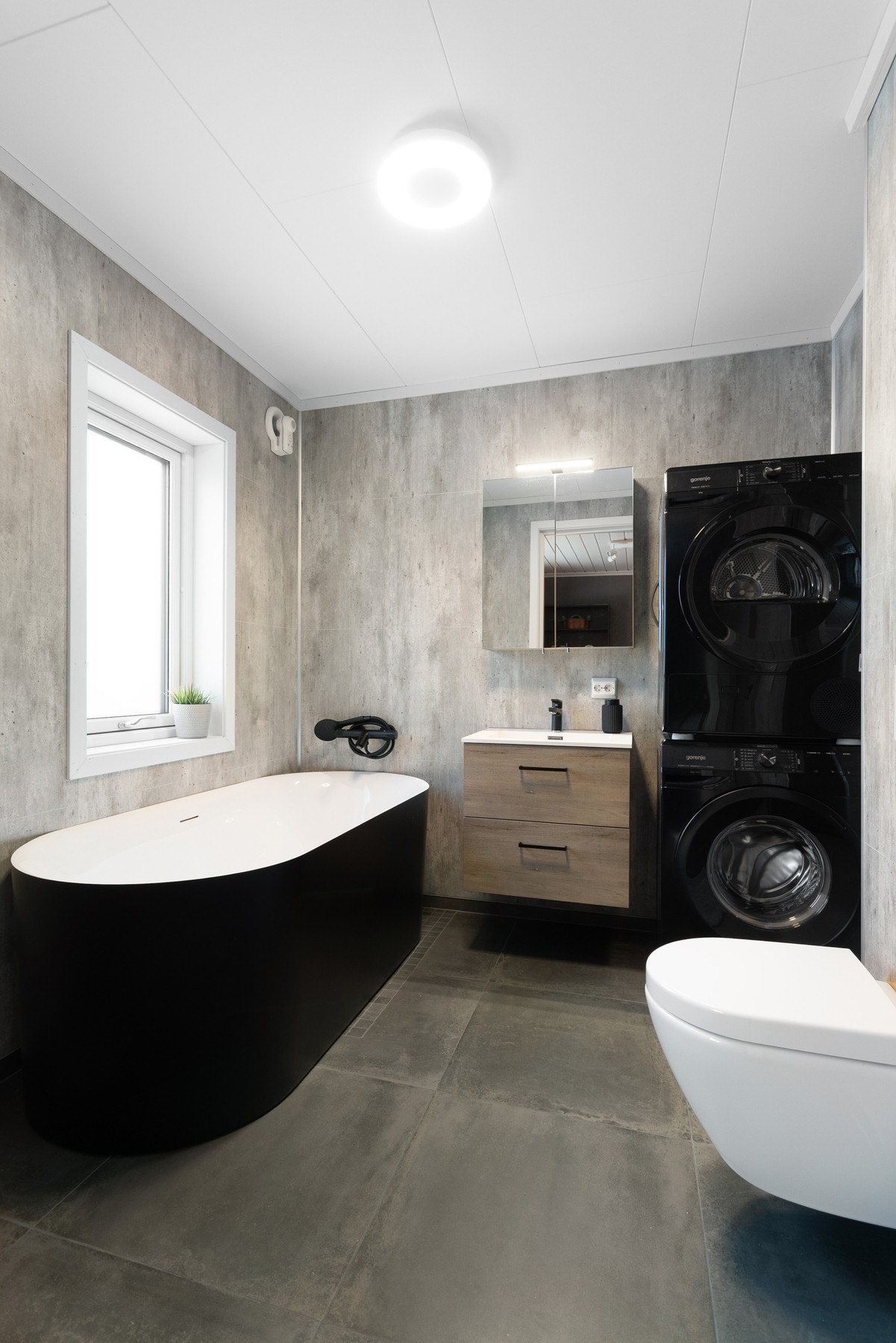 Innredet med badekar, toalett, baderomsinnredning med servant og speil, samt opplegg for vaskemaskin. Galleribilde