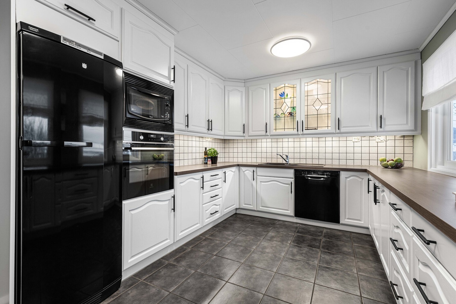 Innholdsrikt kjøkken med rikelig skap- og benkeplass. Galleribilde