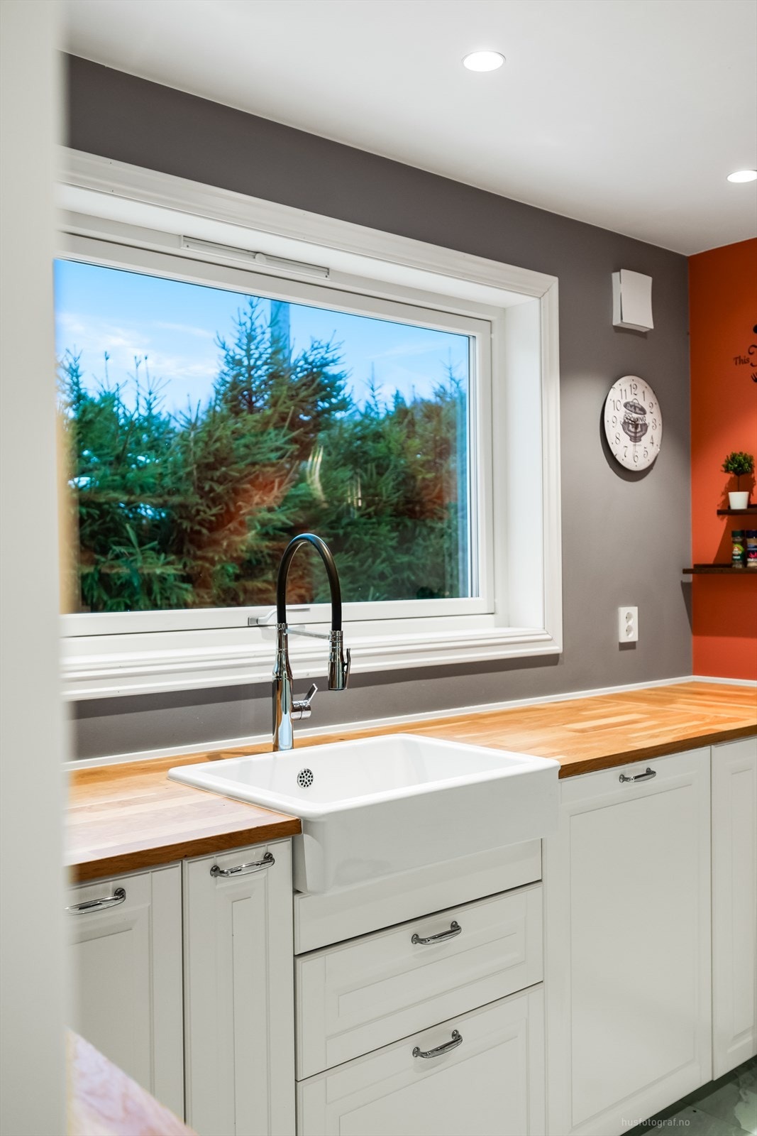 Stor porselensvask og benkeplate i heltre gir kjøkkenet et landlig preg. Galleribilde