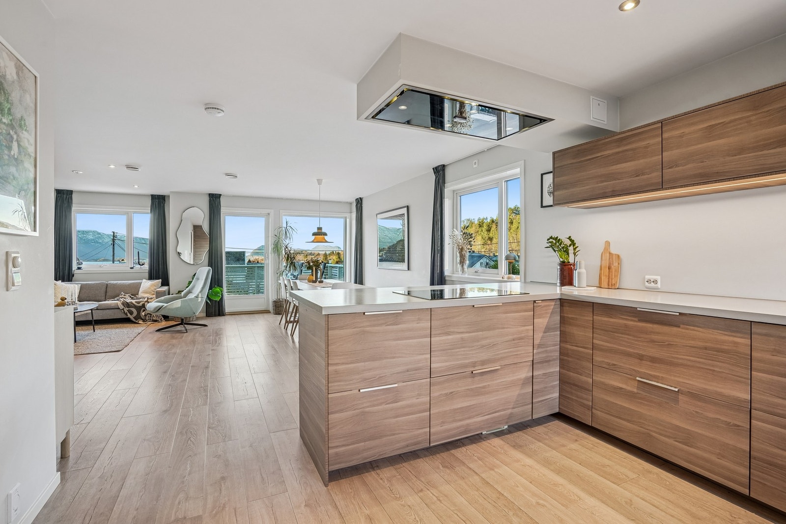 Åpen og sosial sone som inviterer til samvær, hvor samtaler med familie og gjester flyter naturlig mens maten tilberedes. Galleribilde