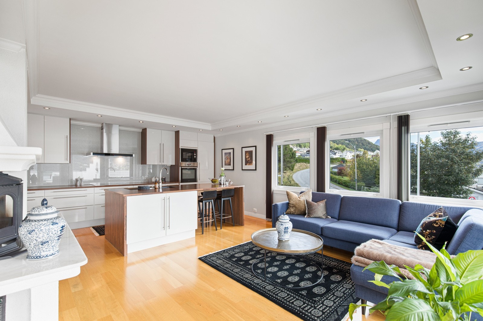 Romslig kjøkken med innredning i hvite, slette fronter og integrerte hvitevarer. Galleribilde