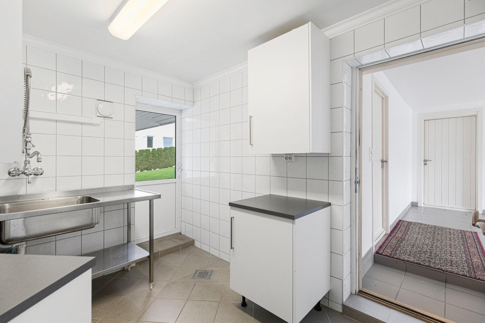 Flislagt vaskerom med tilkomst til dobbelgarasje. Galleribilde