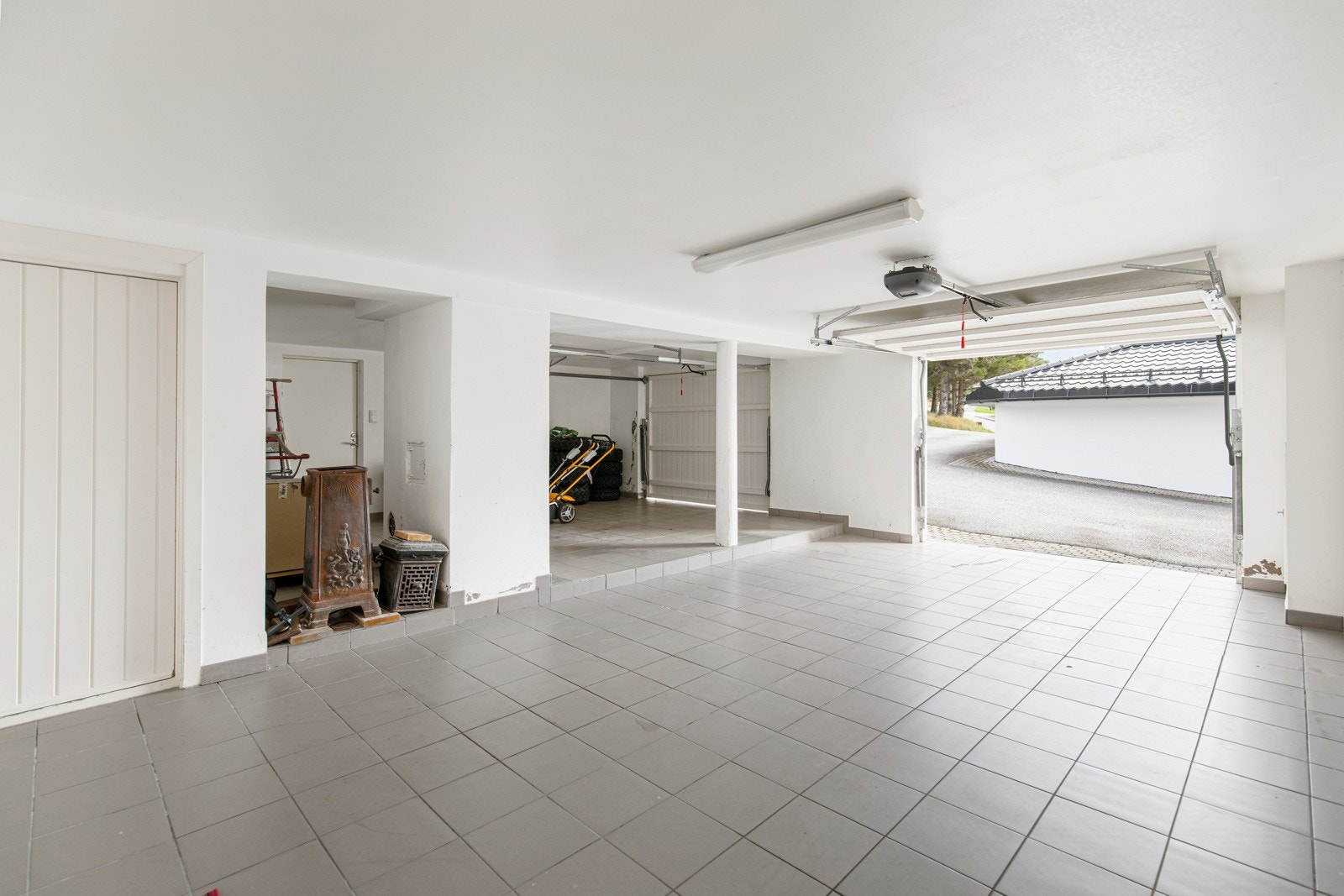 Flislagt dobbelgarasje med tilhørende boder. Galleribilde