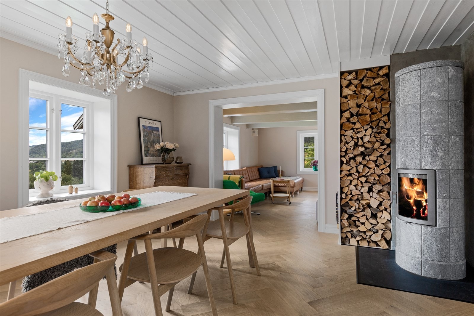 Spisestuen gir et fantastisk førsteinntrykk av boligen med klebersteinsovn og fiskebensparkett. Galleribilde