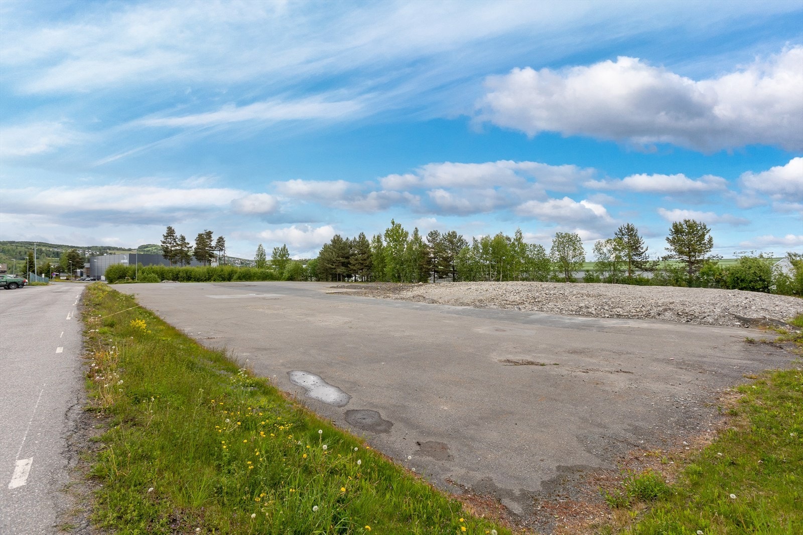 Asfaltert tomt med rester etter revet bygg. Galleribilde