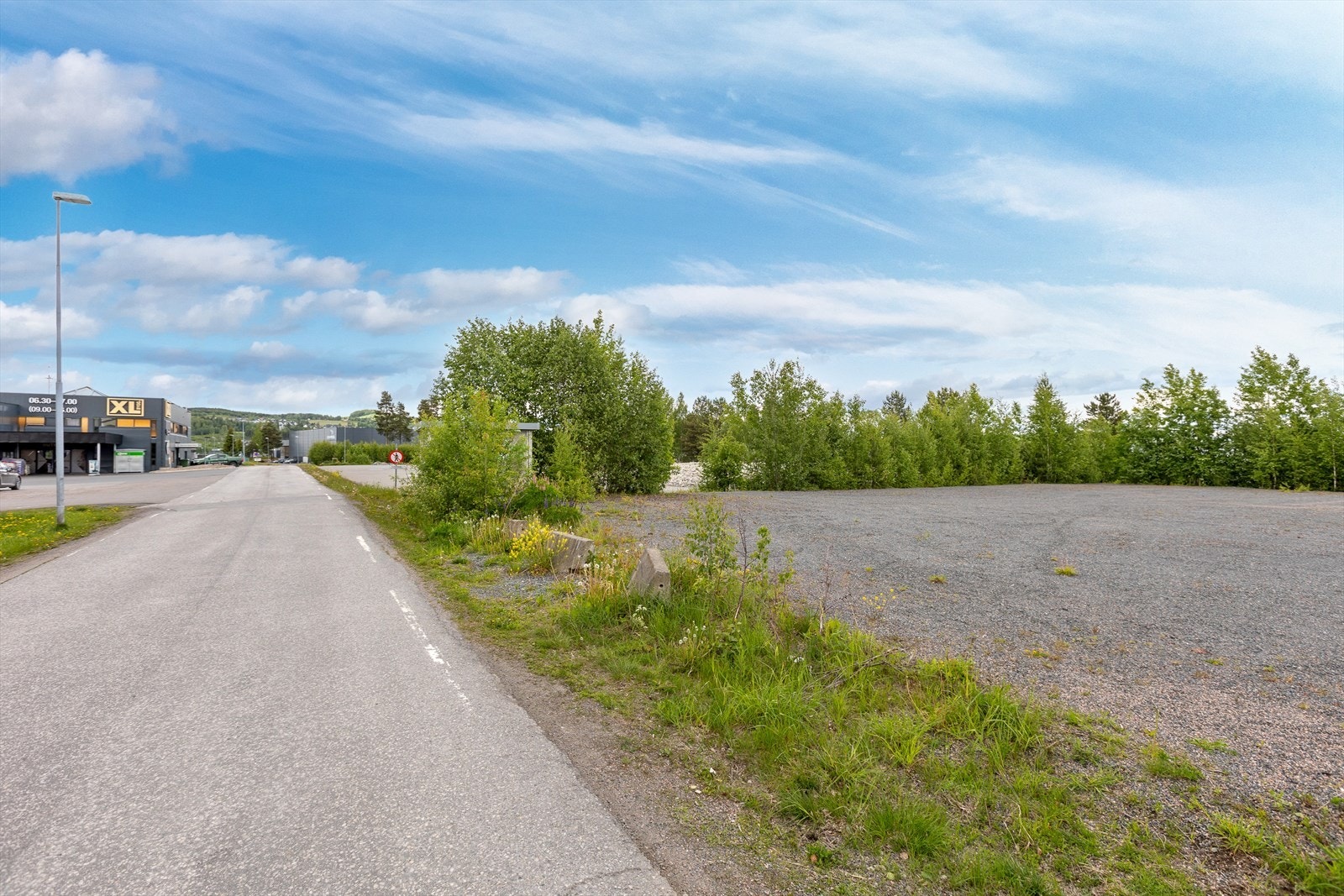 I bildet synes gruset plass til høyre og resten av tomten bak vegetasjonen. Vegen er Thomasdalen mot rv. 4. Galleribilde