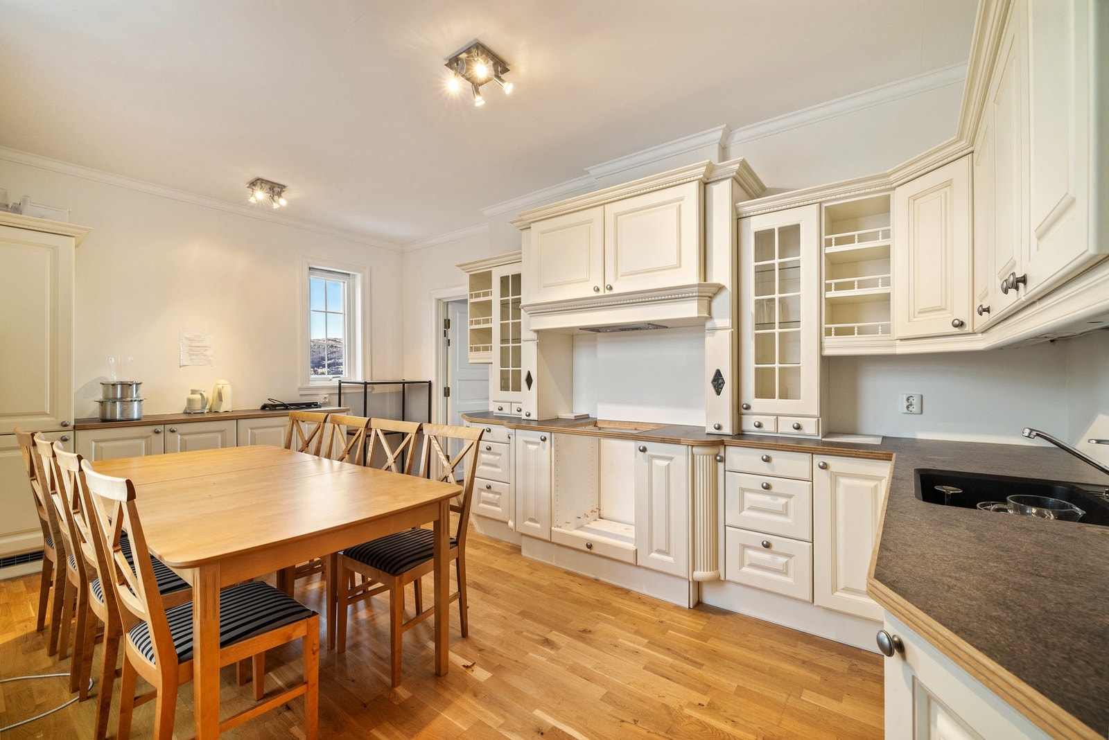 Pent JKE Design kjøkken med profilerte fronter og glasskap, som ble installert i 2009. Galleribilde