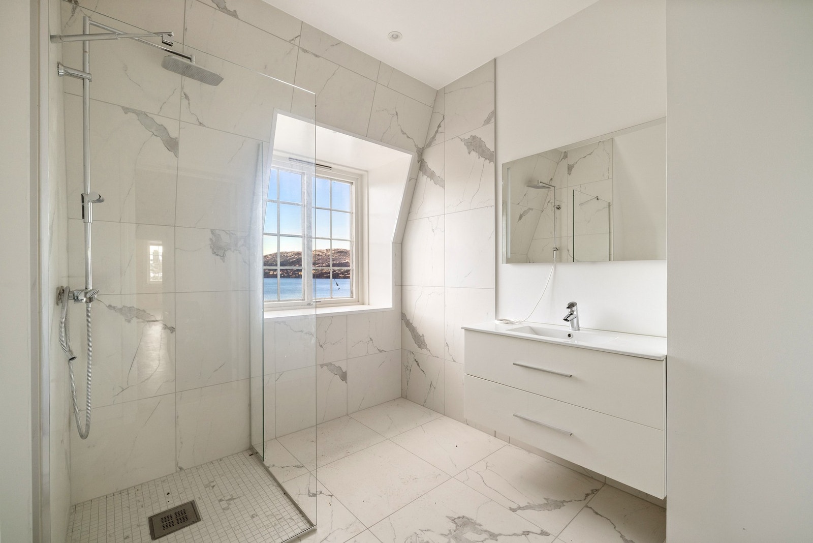 Flott baderom med nydelige fliser og innfelte downlights i himlingen. Flislagt dusjsone og moderne baderomsinnredning Galleribilde