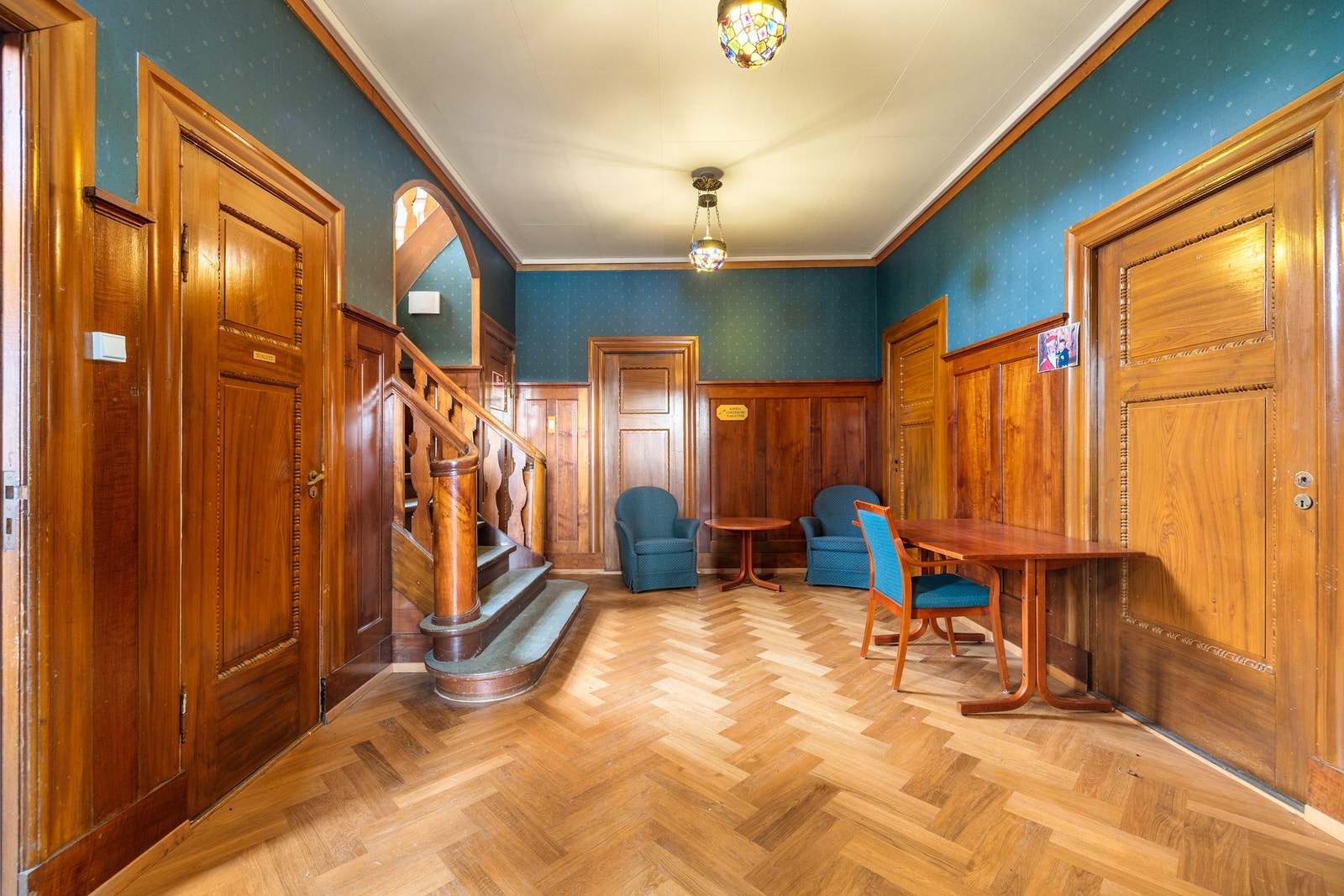 Vakker hall med fiskebensparkett og nydelig brystningspanel i teak på veggene. Galleribilde