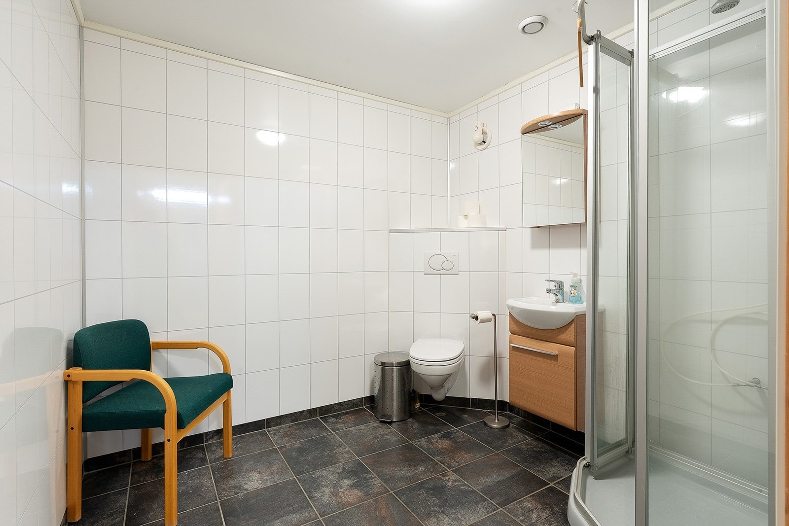 Bad i 1. etasje med dusjkabinett og vegghengt toalett. Flislagt gulv med varmekabler Galleribilde