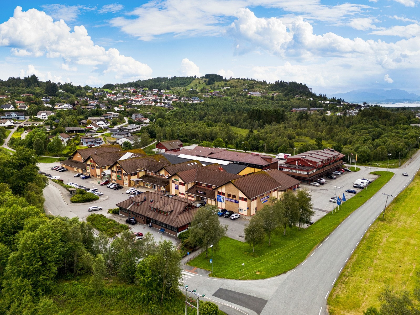 Oversiktsbilde Lindås Nærsenter med bla. Rema 1000, Kiwi, Europris, Trend Skruen, apotek, Mova treningssenter m.fl. Galleribilde