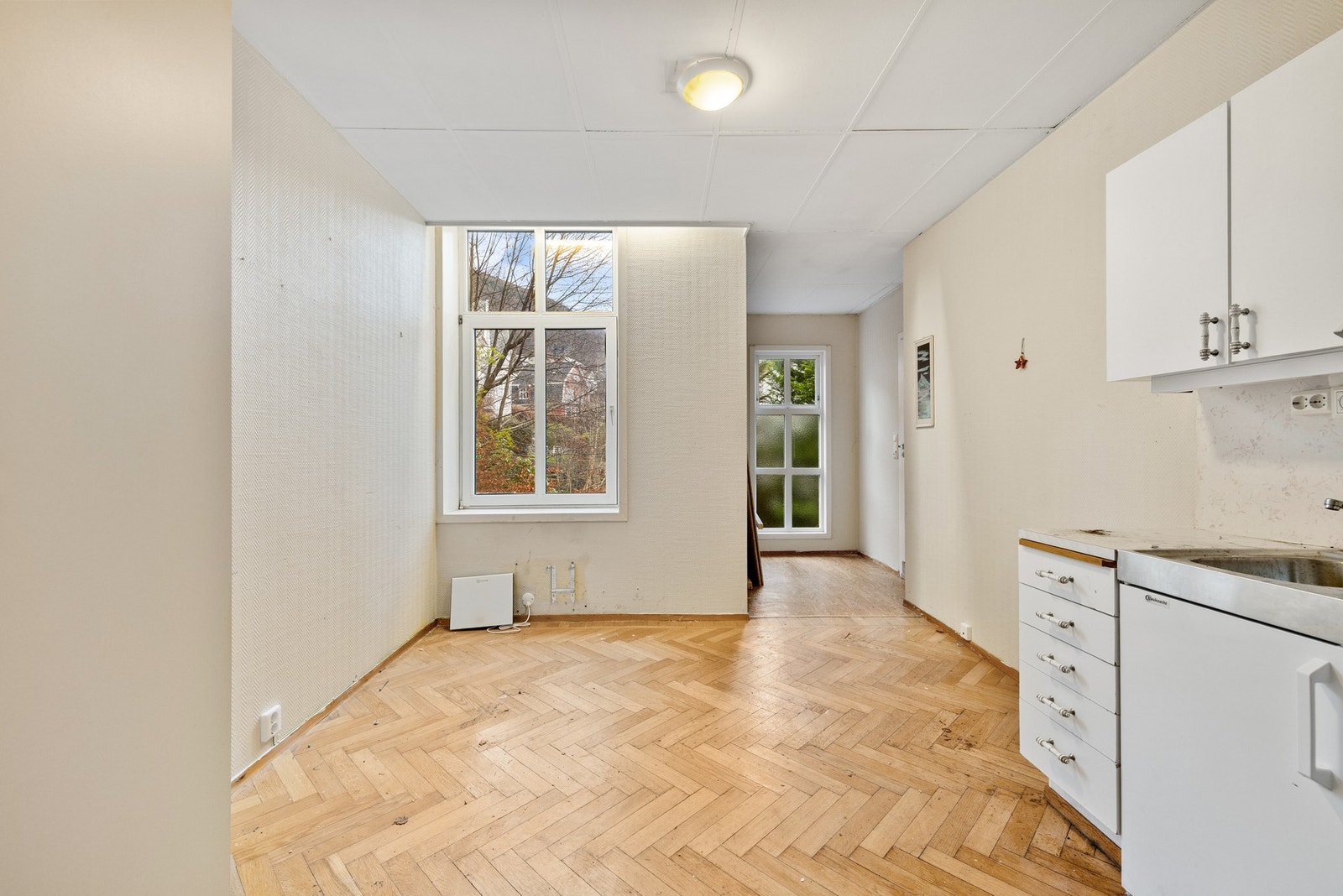 Utsnitt av det ene hybelrommet. Kjøper må påregne omfattende rehabilitering. Galleribilde