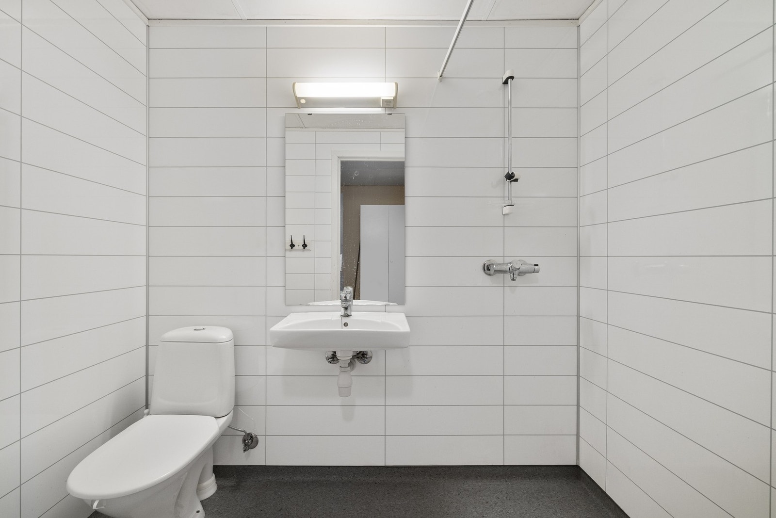 Baderom med våtromsplater, servant og dusjsone. Galleribilde