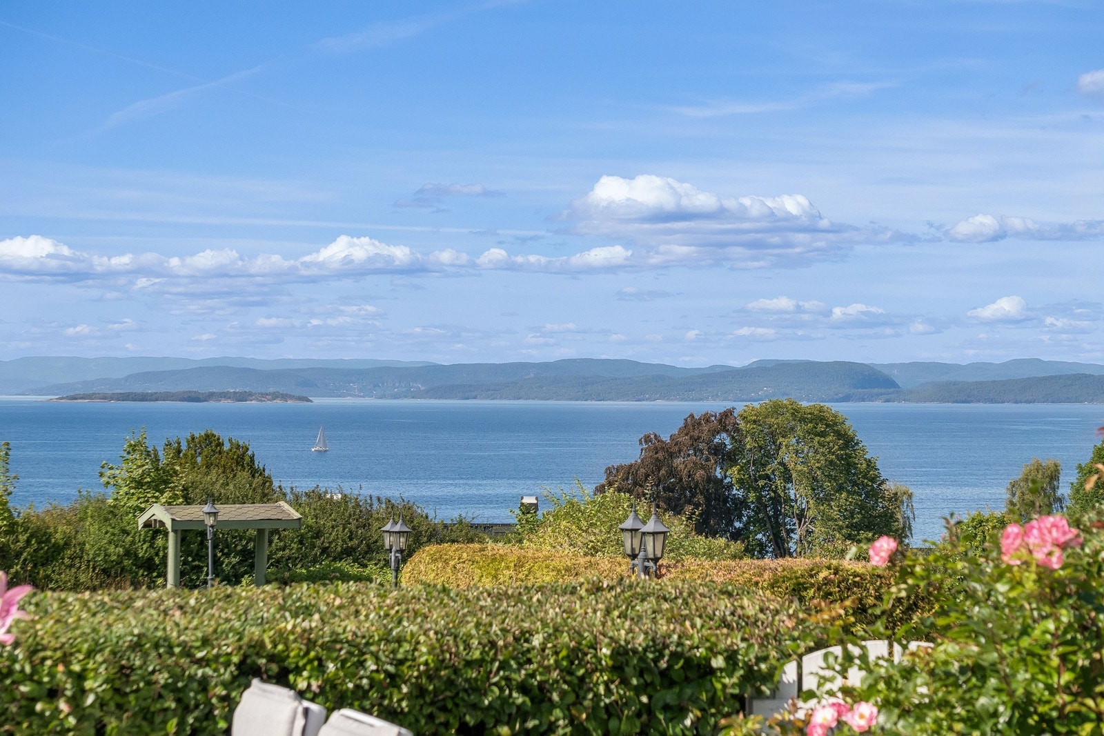 Selger har montert en liten hvitmalt port ut til fellesarealet. Derfra er det kort vei ned til Refsnes Gods sin flotte strand og brygge. Galleribilde