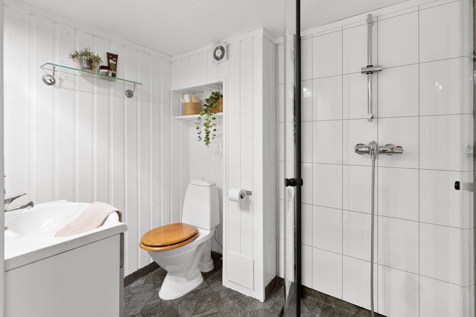 Baderom med toalett, dusjhjørne og vask med baderomsmøblement. Galleribilde