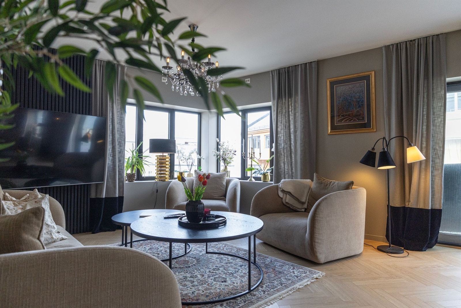 Elegant spilevegg tilfører stuen et moderne og stilrent uttrykk, mens lune og harmoniske fargetoner skaper en behagelig atmosfære. Fargevalgene gjør det enkelt å supplere med egne møbler og tekstiler. Galleribilde