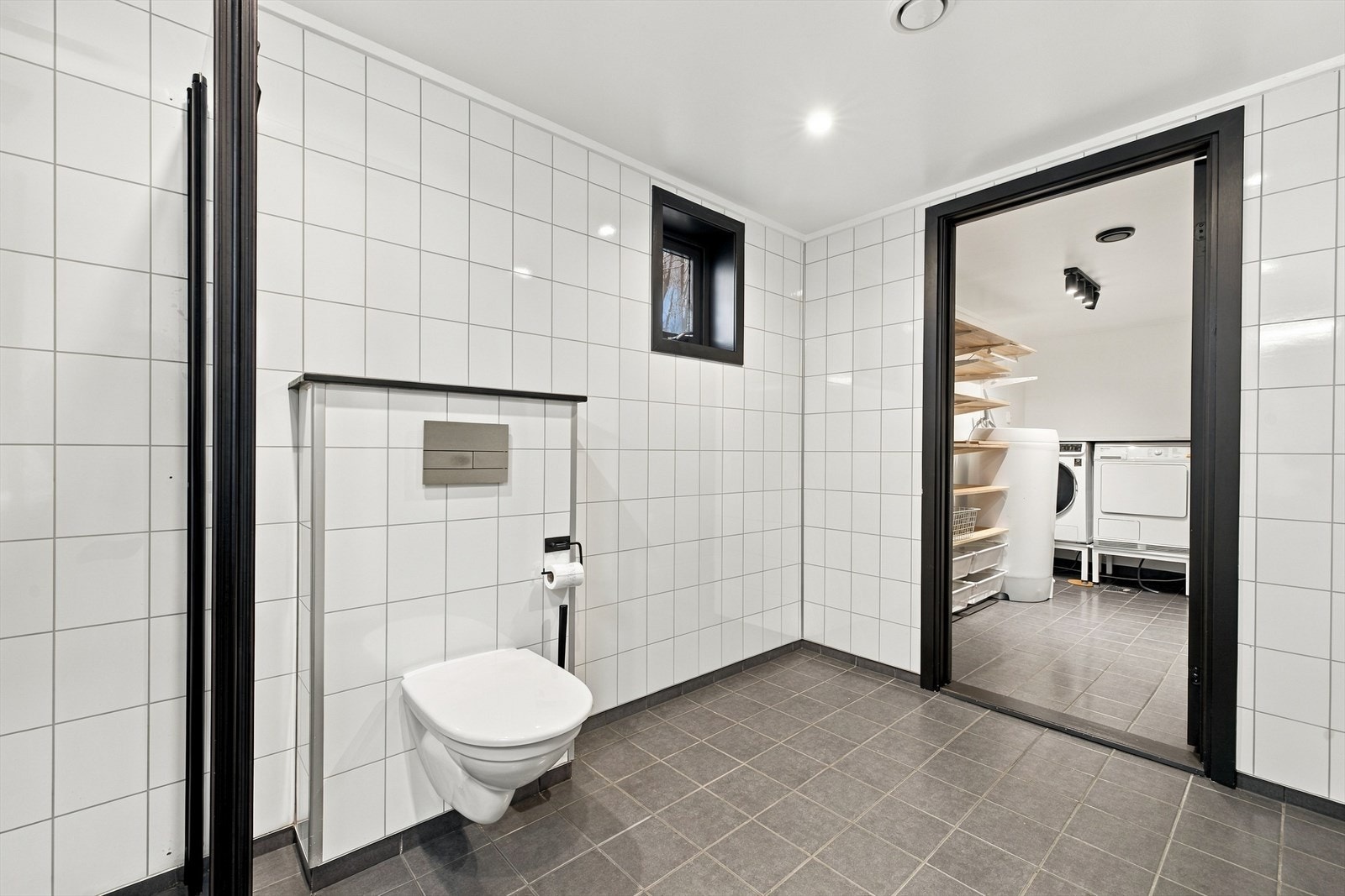 Badet er praktisk innredet med pen baderomsmøbel med servant, speil med belysning, vegghengt toalett og dusj med foldedører i herdet glass. Galleribilde