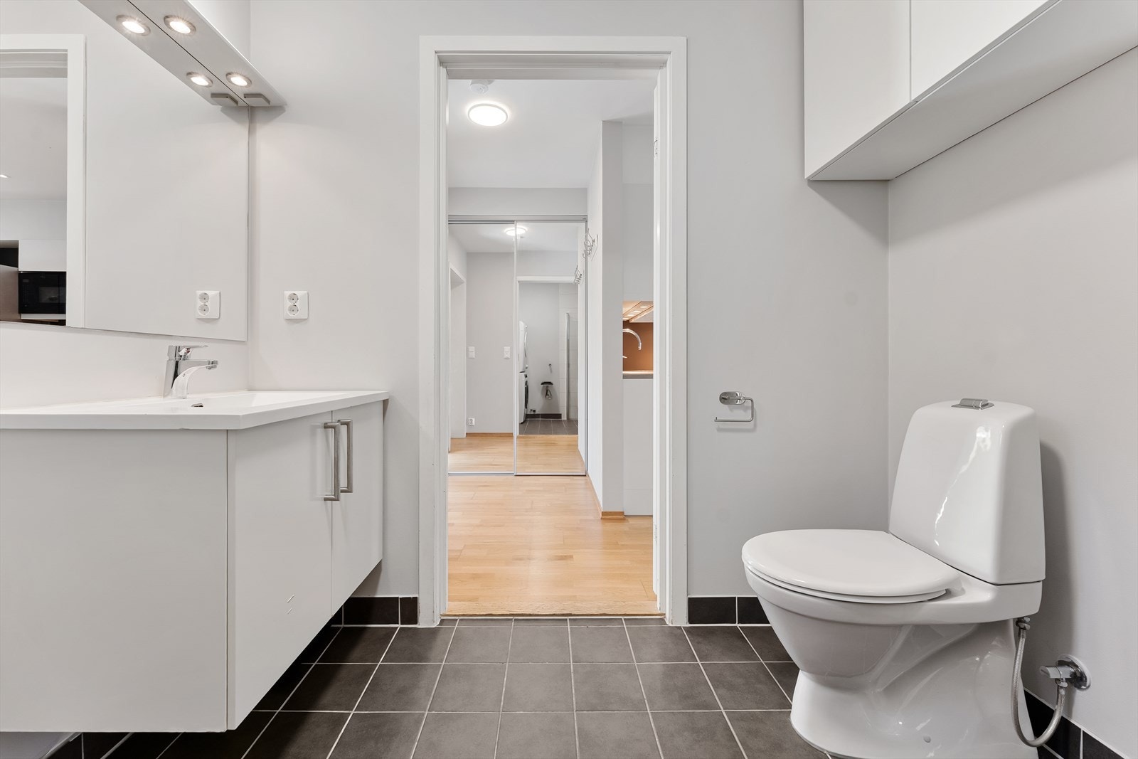 Badet har også fliser i dusjsonen og ellers malte flater. Innredningen består av underskap, servant og speil, samt toalett og dusj. Galleribilde