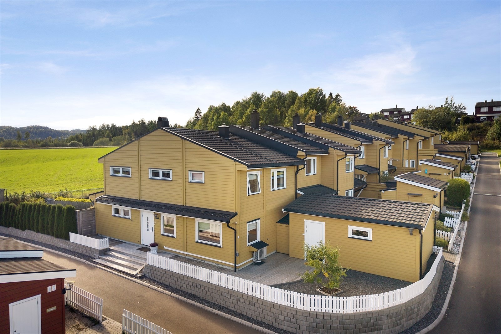 Støttemur med gjerde og hekk rammer alt inn på en veldig pen måte Galleribilde
