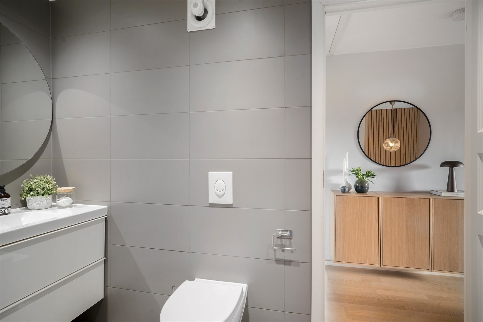 Videre er badet innredet med vegghengt toalett, fuktstyrt vifte, moderne innredning, gulvvarme og downlightsbelysning Galleribilde