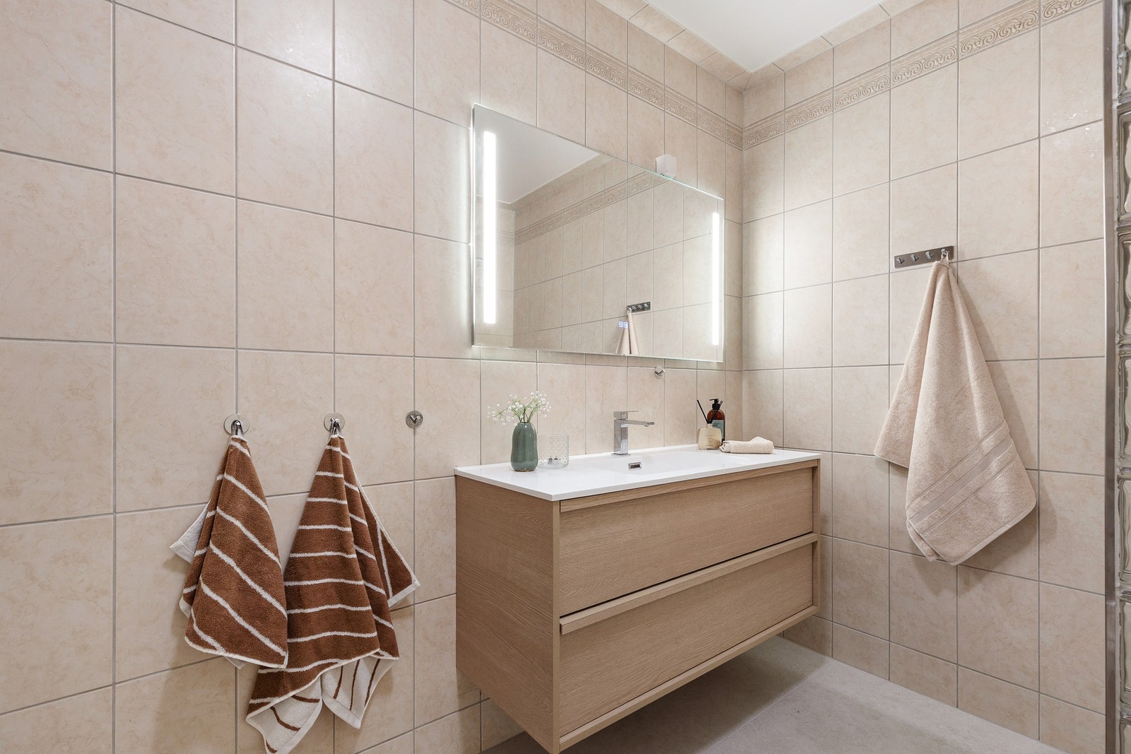 Badet består av servant med underskap, speil med integrert LED lyd, klosett, dusjhjørne og opplegg for vaskemaskin Galleribilde