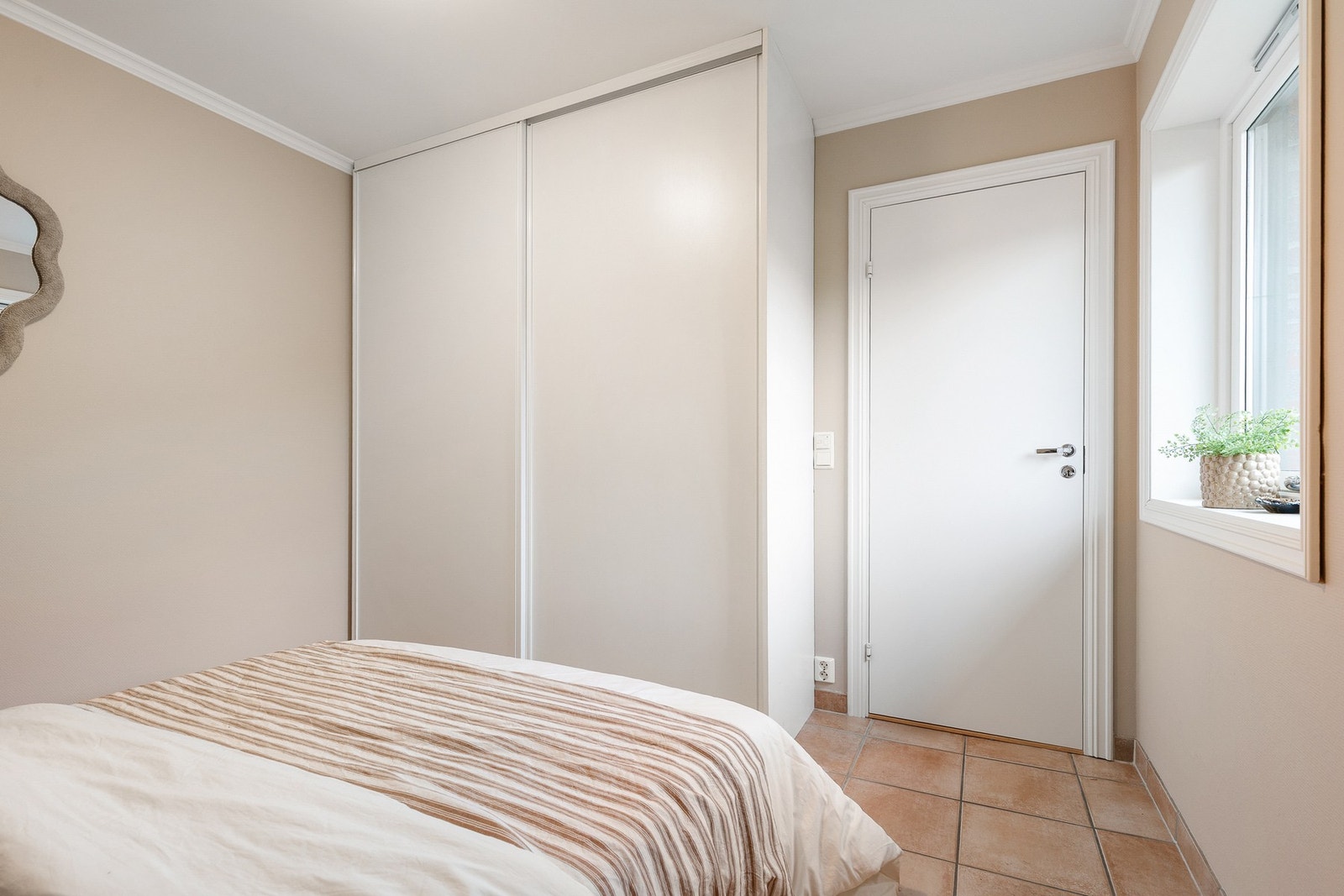 Det er montert skyvedørsgarderobe og fliser med gulvvarme Galleribilde