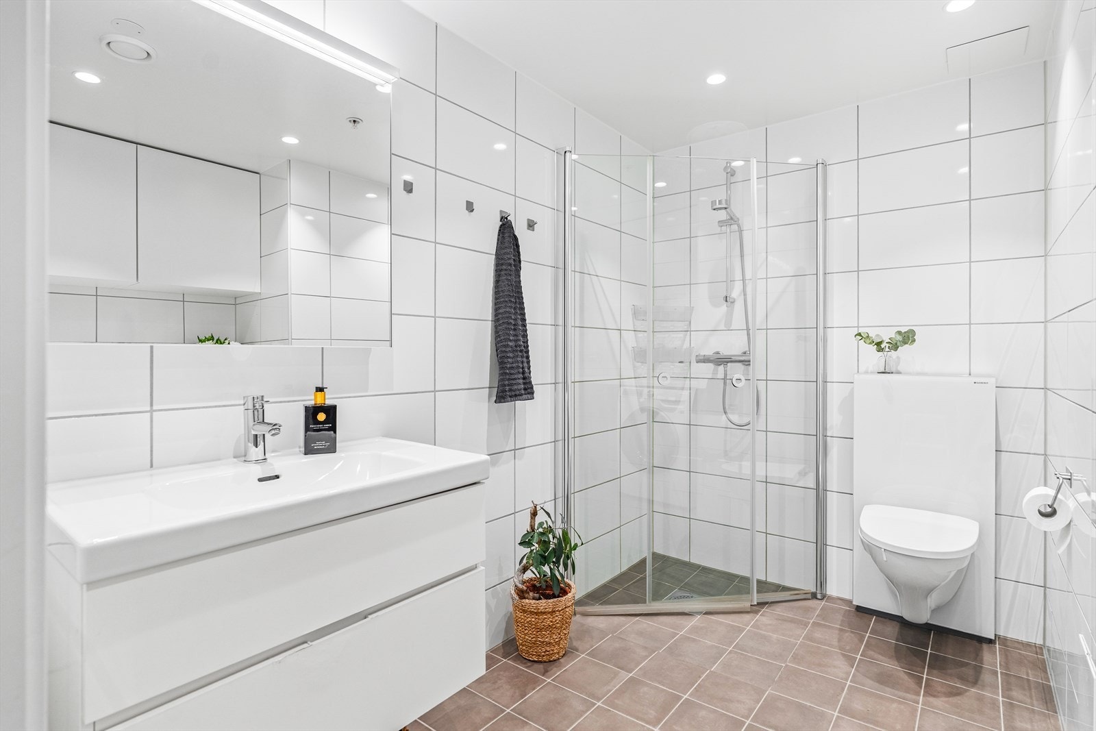 Badet fremstår moderne og funksjonelt med flislagte gulv og vegger, gulvvarme og downlights i himlingen. Galleribilde