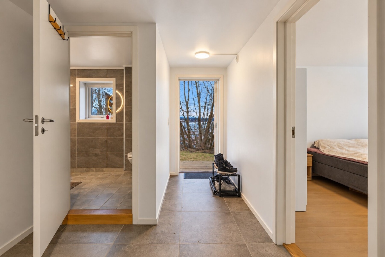Lys og innbydende entré med flislagt gulv som er praktisk i hverdagen, samt god plass til oppheng av yttertøy og sko. Galleribilde