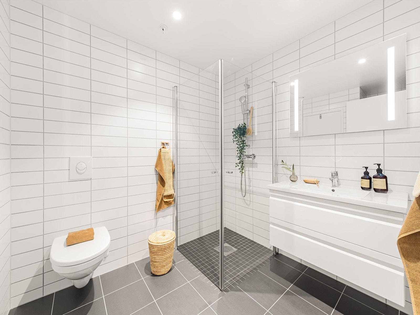 Moderne og pent helfliset baderom med vannbåren gulvvarme. Galleribilde
