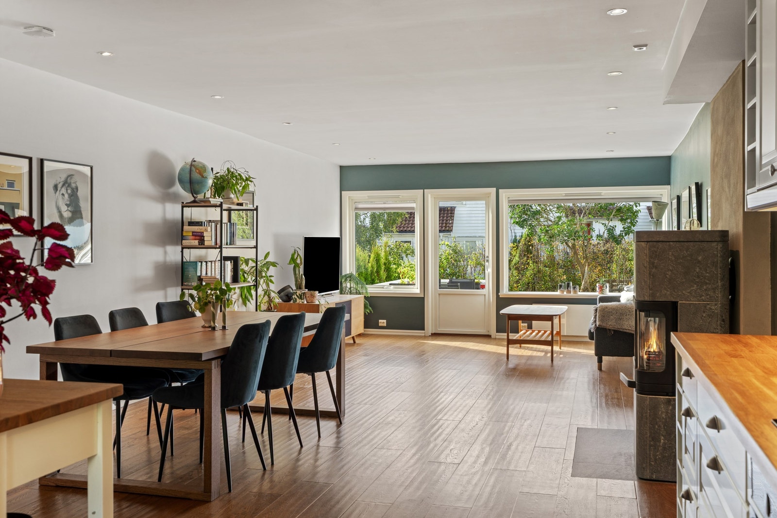 Stue og kjøkken i åpen løsning med peisovn fra 2019 og direkte utgang til terrassen. Foto: Martin Nordbø Galleribilde